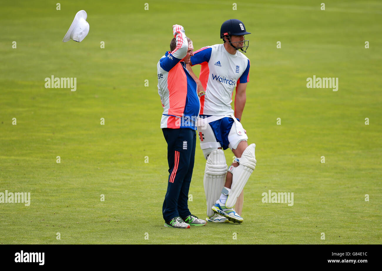 England-Cheftrainer Trevor Bayliss verliert seinen Hut im Wind, während er mit Alastair Cook während der Nets-Session vor dem ersten Investec Ashes Test im SWALEC Stadium in Cardiff chattet. Stockfoto