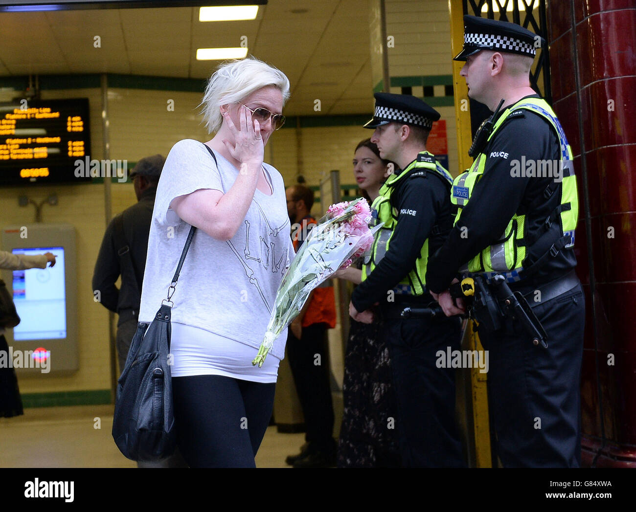 Eine Frau, die Blumen trägt, verlässt die Londoner U-Bahnstation Russell Square, während Großbritannien sich an die Angriffe vom 7. Juli erinnert, und dabei ein ganzes Jahrzehnt lang vor der anhaltenden und sich ändernden Bedrohung durch den Terrorismus warnte. Stockfoto
