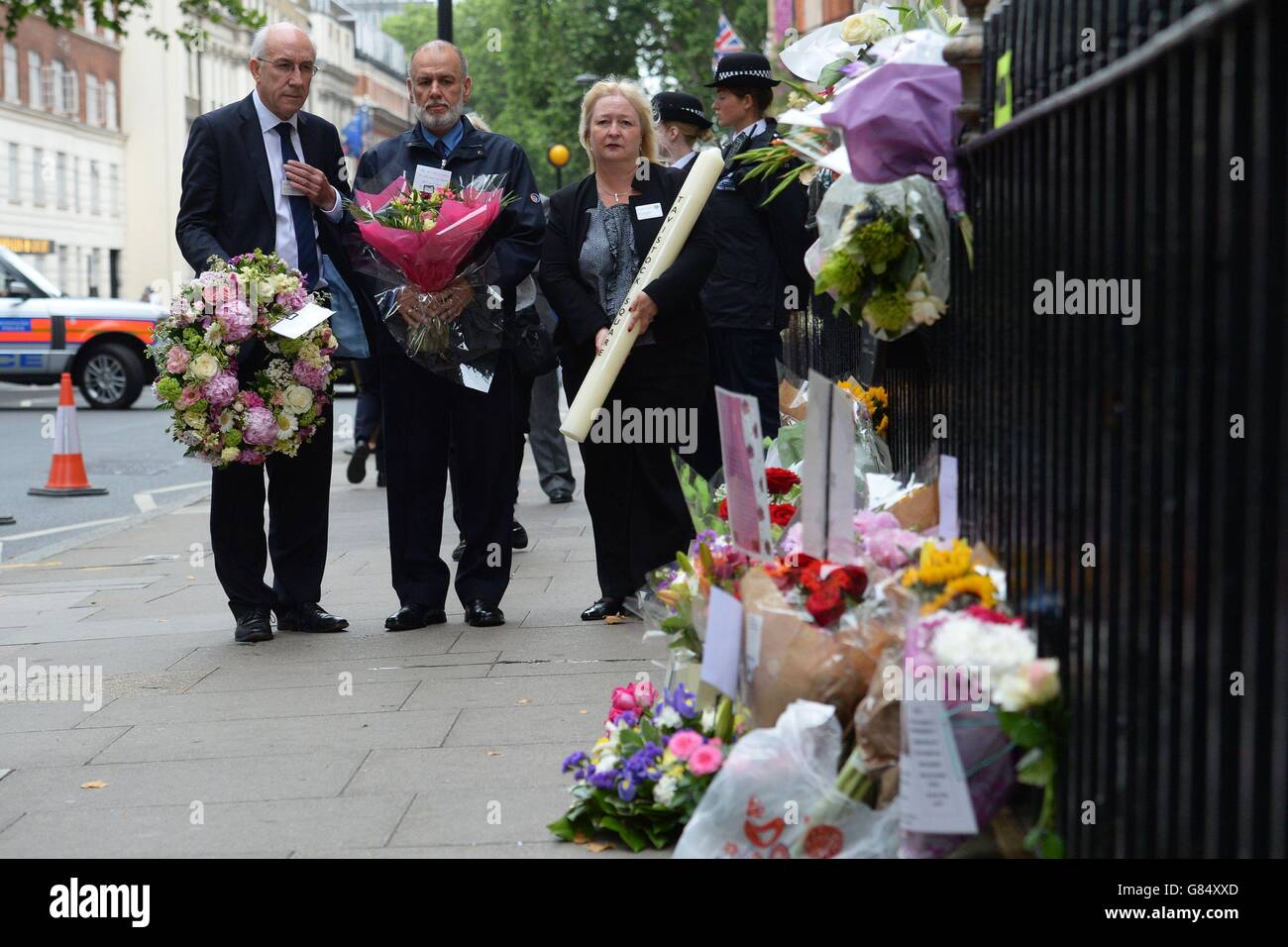 George Psaradakis (zweiter links), der Fahrer des Buses Nummer 30, der auf dem Tavistock Square gesprengt wurde, schaut auf die Blumen, die in der Nähe der Bombenanschläge in London zurückgeblieben sind, Großbritannien erinnert sich an die Anschläge vom 7. Juli inmitten einer ganzen Wange von Warnungen vor der anhaltenden und sich ändernden Bedrohung durch den Terrorismus ein Jahrzehnt später. Stockfoto