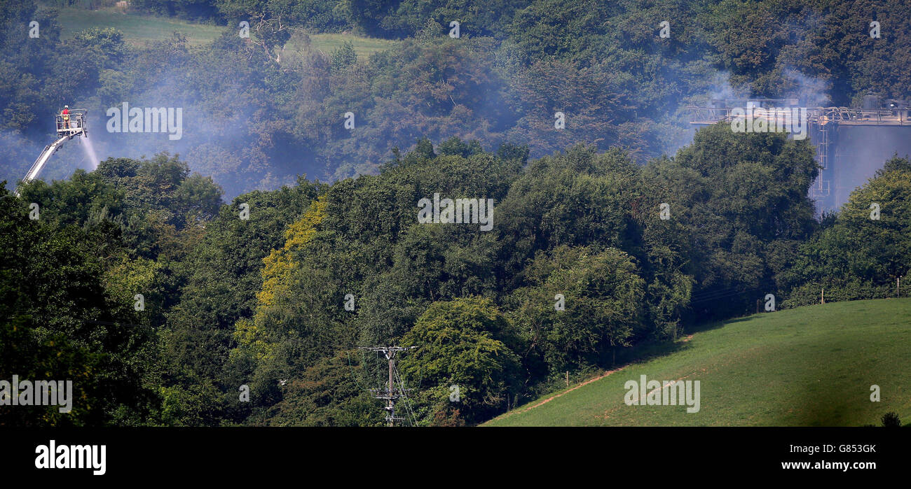 Ein Feuerwehrmann dämpft den Ort einer Explosion und eines Feuers, an dem vier Personen in den Wood Flour Mills in Bosley, in der heshire, noch vermisst werden. Stockfoto