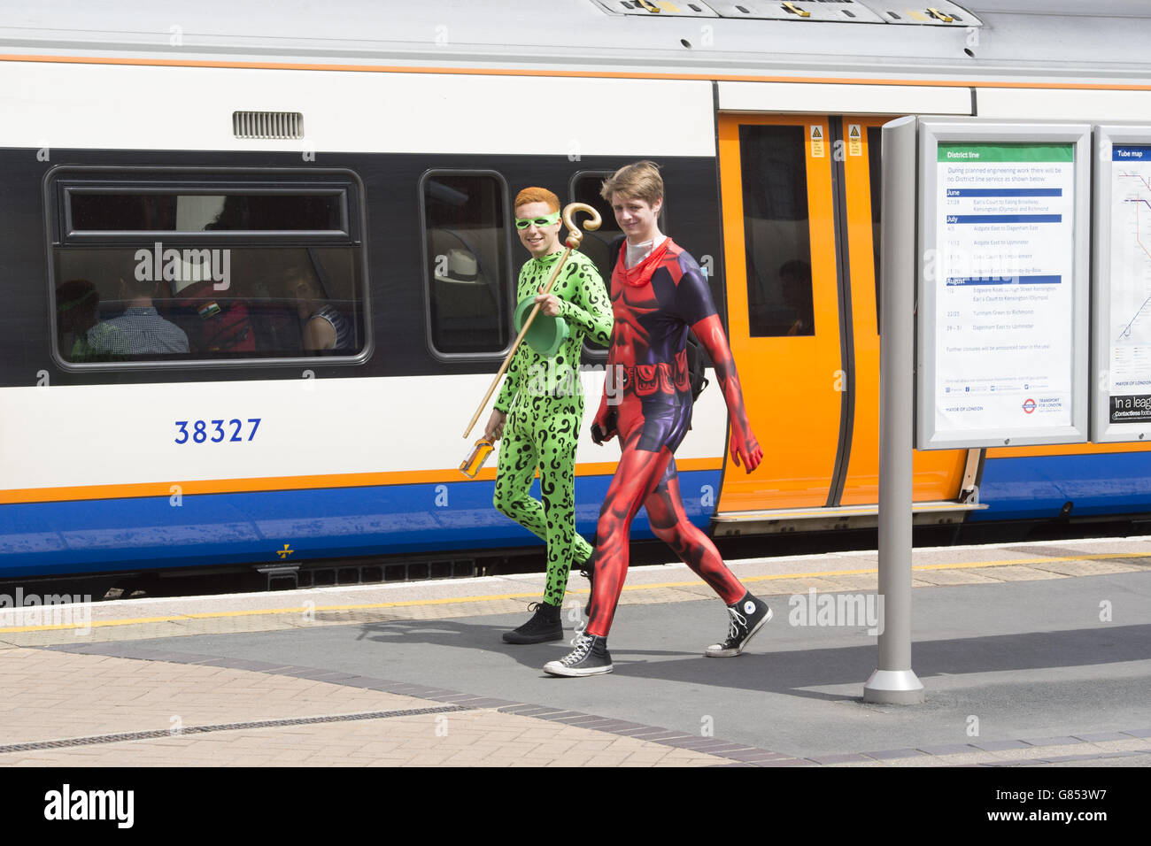 Besucher in Kostümen kommen vor der London Film and Comic Con im Olympia in Kensington, London, an der Kensington Olympia Station an. Stockfoto