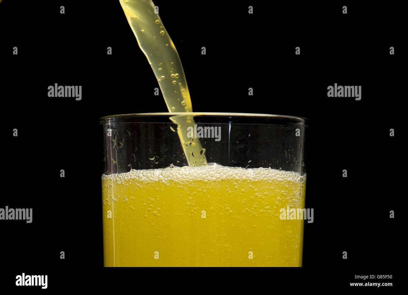 Ein orangefarbenes kohlensäurehaltiges Getränk, das als Getränk mit zuckerhaltigen Getränken gegossen wird, könnte laut Forschung fast 8,000 Fälle von Typ-2-Diabetes pro Jahr verursachen. Stockfoto