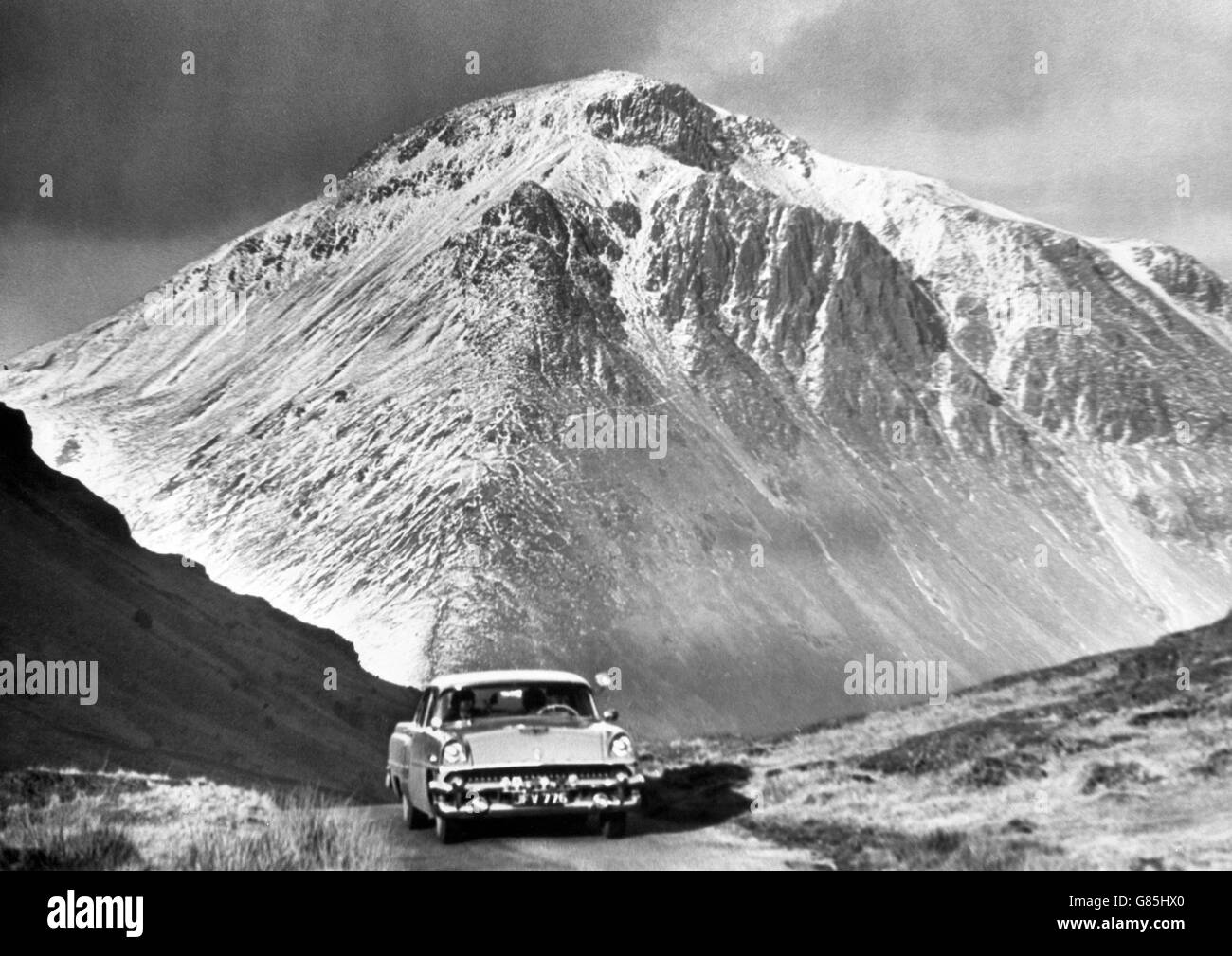 Ein Ford Mercury Auto fährt durch den Lake District und entdeckt die fast alpine Winterschönheit am Great Gable, einem der beliebtesten Klettergipfel Großbritanniens. Stockfoto
