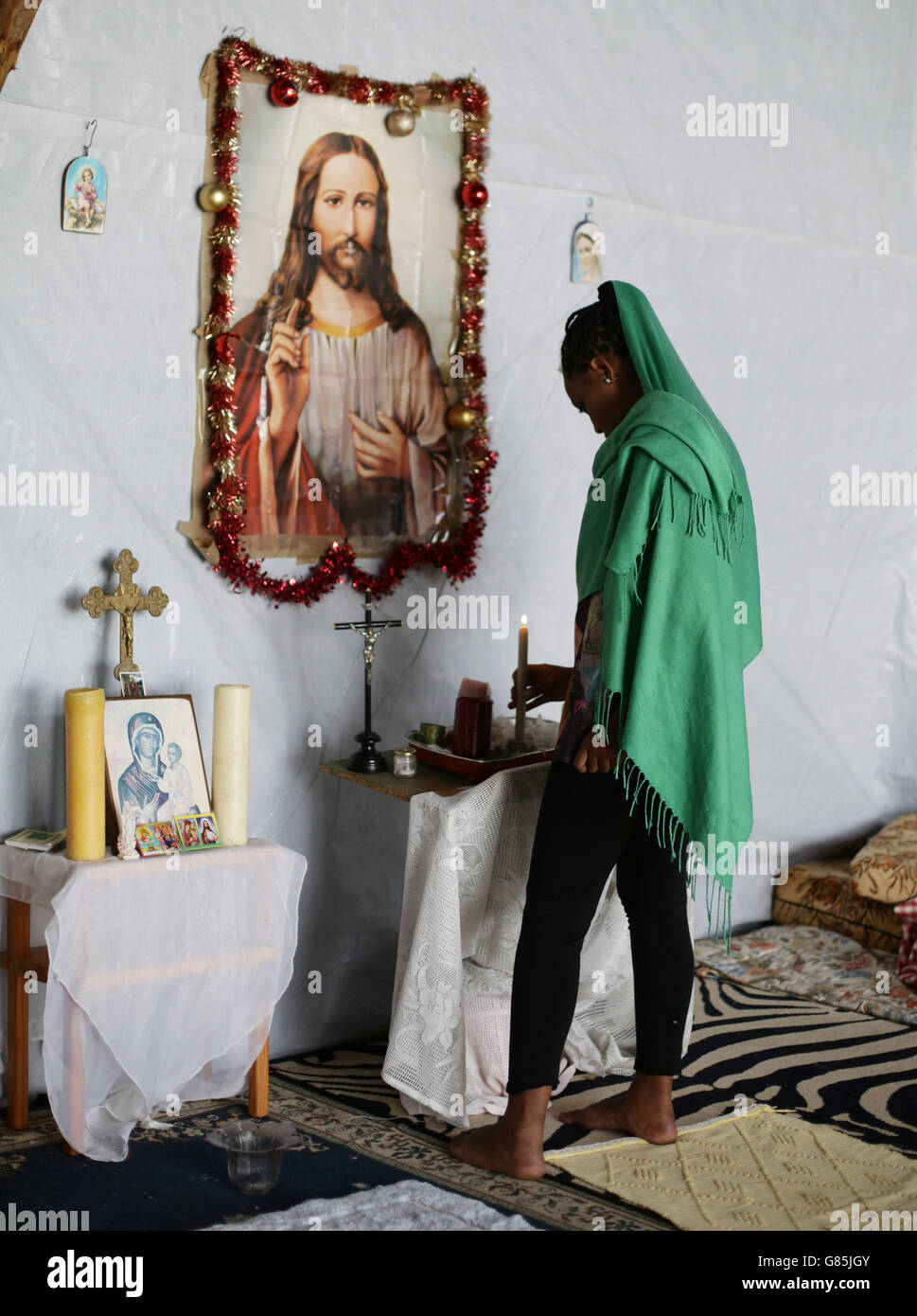 Ein Gläubiger in einer äthiopisch-orthodoxen Kirche, die im Flüchtlingslager „der neue Dschungel“ in Calais, Frankreich, errichtet wurde. Stockfoto