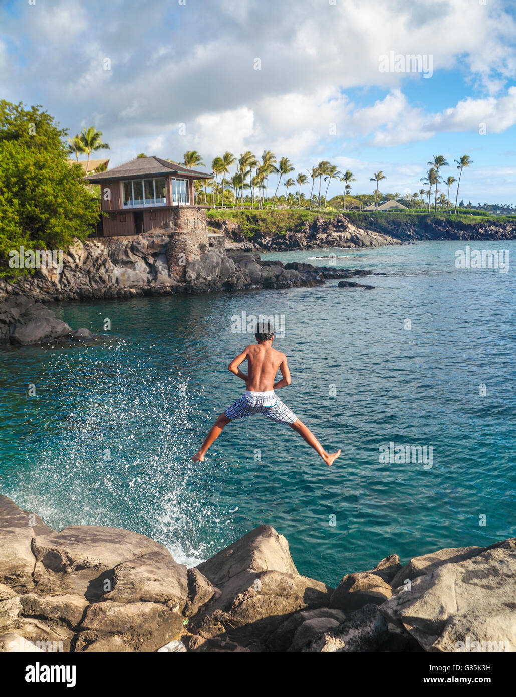 Junge springt ins Meer in Kapalua nahe dem Cliff House Stockfoto