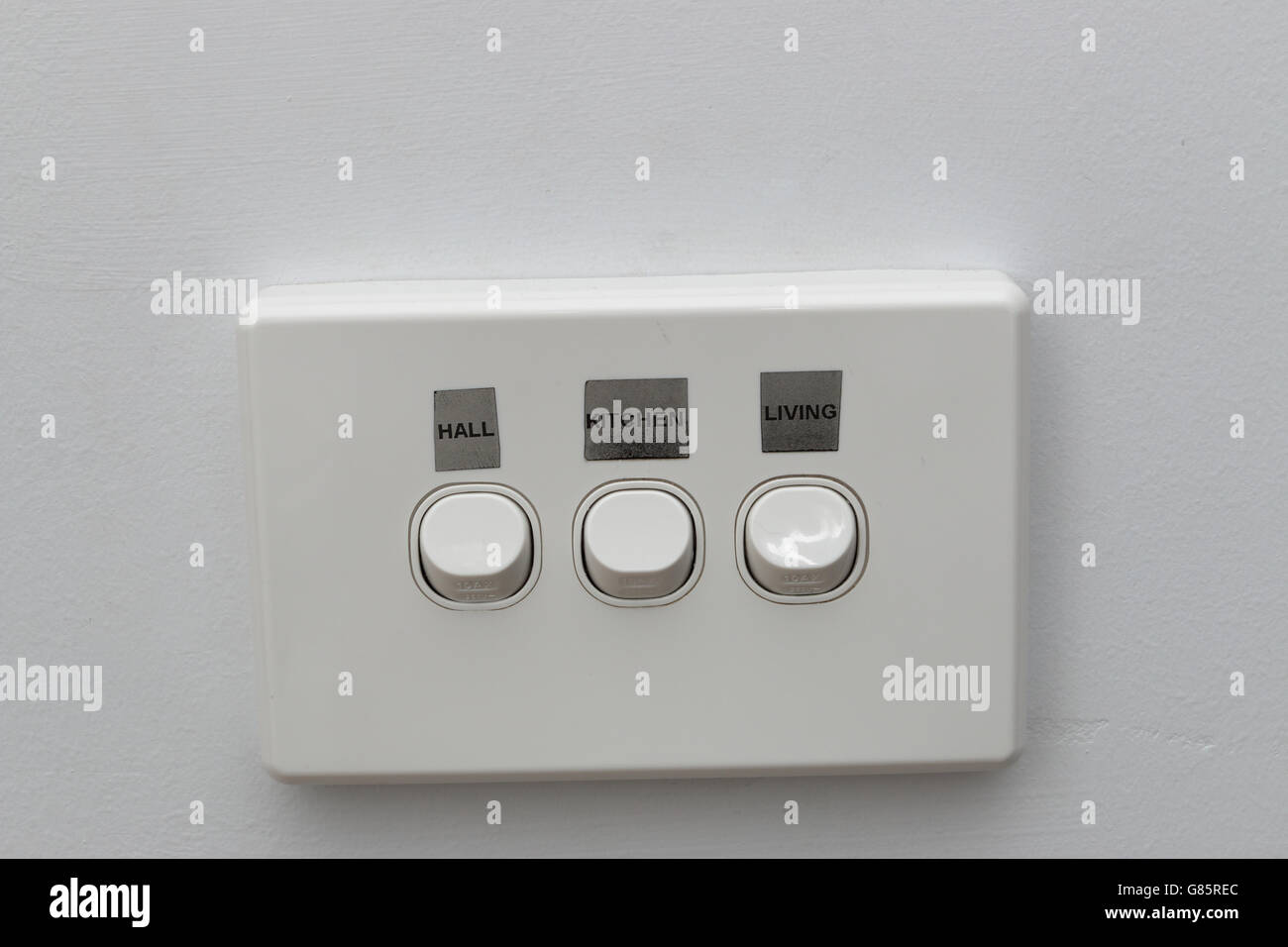Close up Portrait of Light Switch mit Etiketten auf der weißen Wand Stockfoto