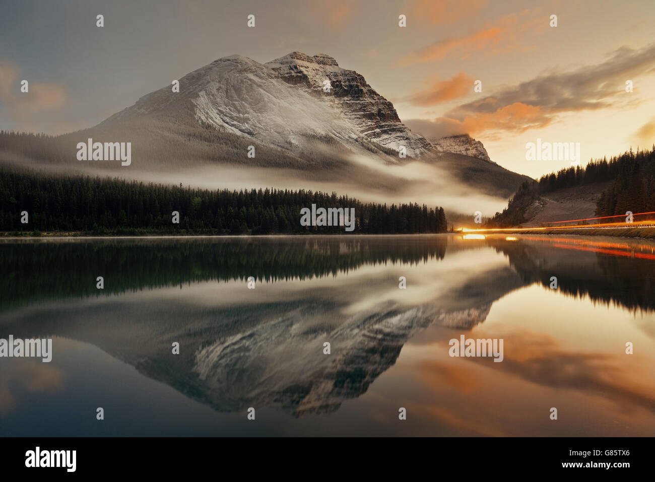 Bergsee und Ampel Wanderweg mit Reflexion und Nebel bei Sonnenuntergang in Banff Nationalpark, Kanada. Stockfoto
