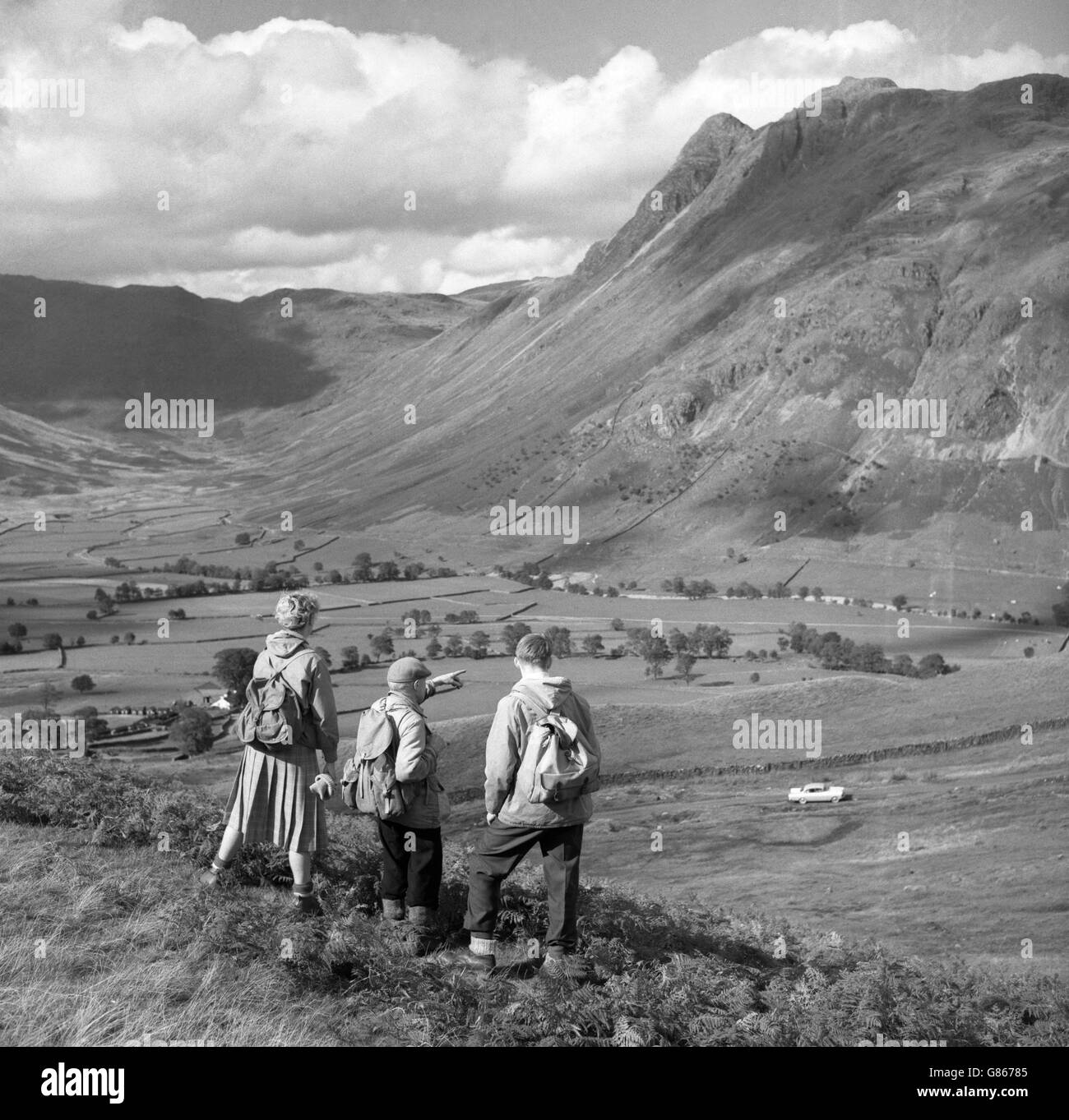 Fell Walkers genießen einen herbstlichen Blick auf Langdale Pikes im Lake District. Stockfoto