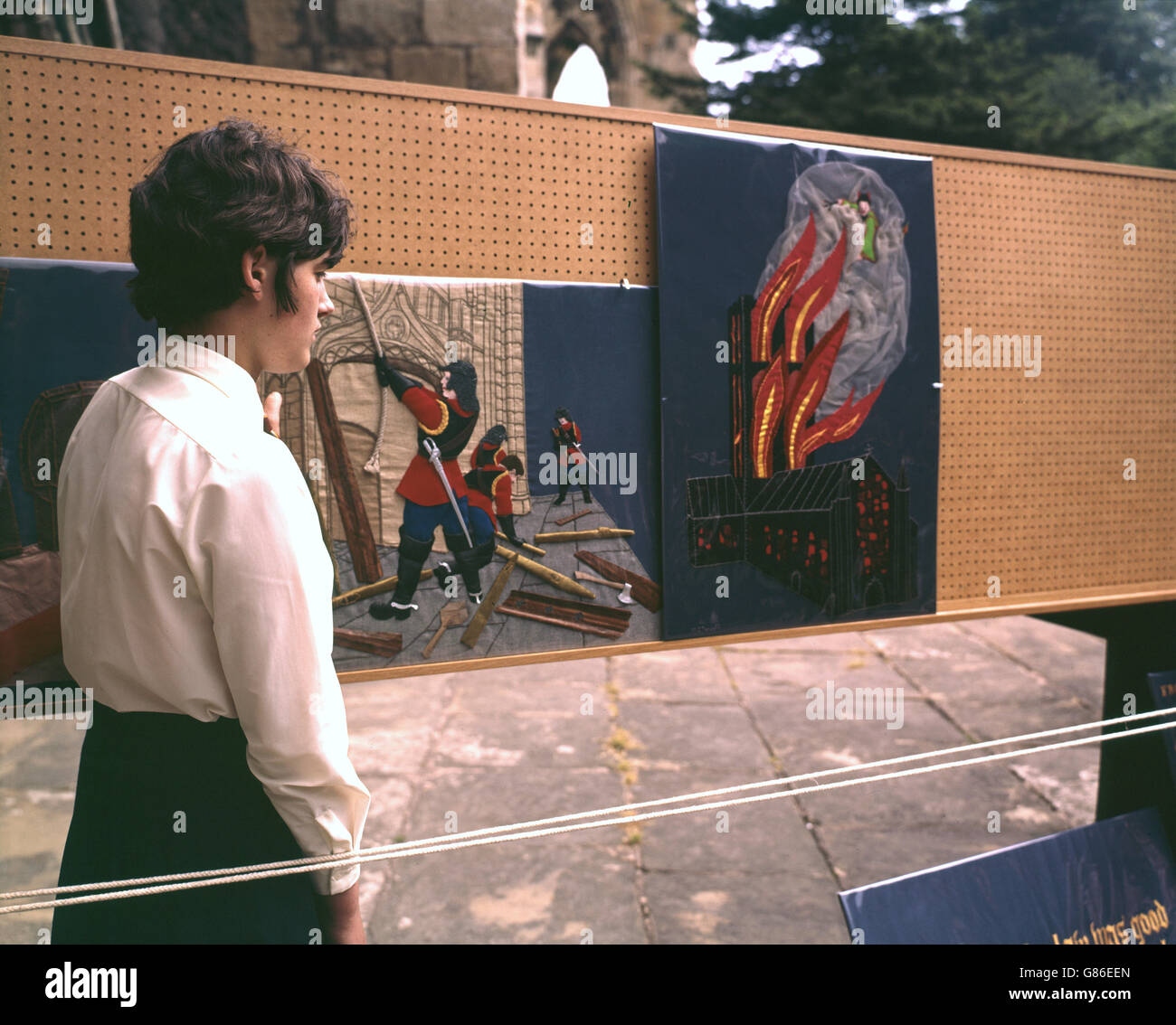Janet Hopkinson, 15, zeigt zwei Tafeln des Howden-Tapisserie, die im Zusammenhang mit dem 700. Jahrestag der Stiftskirche St. Peter, Howden, Yorkshire, gezeigt wurden. Diese zeigen Roundheads und ein Feuer im Jahr 1929, das den Turm der Kirche zerstört, später restauriert. Stockfoto