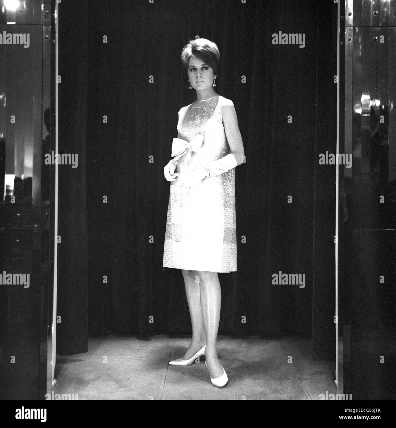 Das Model Angela trägt ein Organza-Kleid mit Pailletten und Paletten. Das Kleid mit dem Namen 'Roulette' ist Teil der Norman Hartnell Frühjahr und Sommer Kollektion 1966. Stockfoto