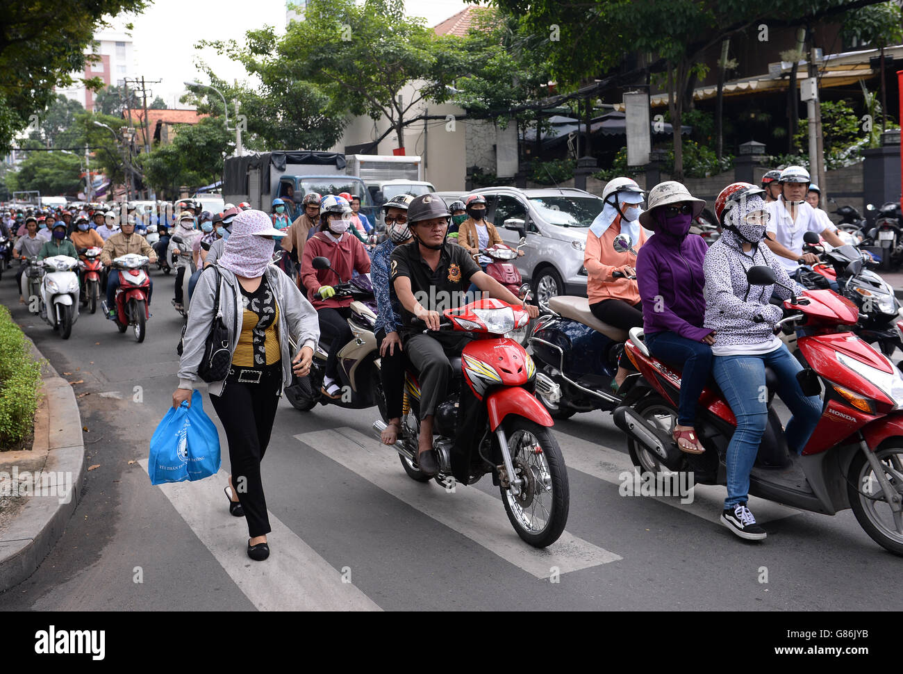 Pendler warten an der Ampel in Ho-Chi-Minh-Stadt in Vietnam, wo etwa 43 Millionen Menschen Motorräder als Verkehrsmittel nutzen. Stockfoto