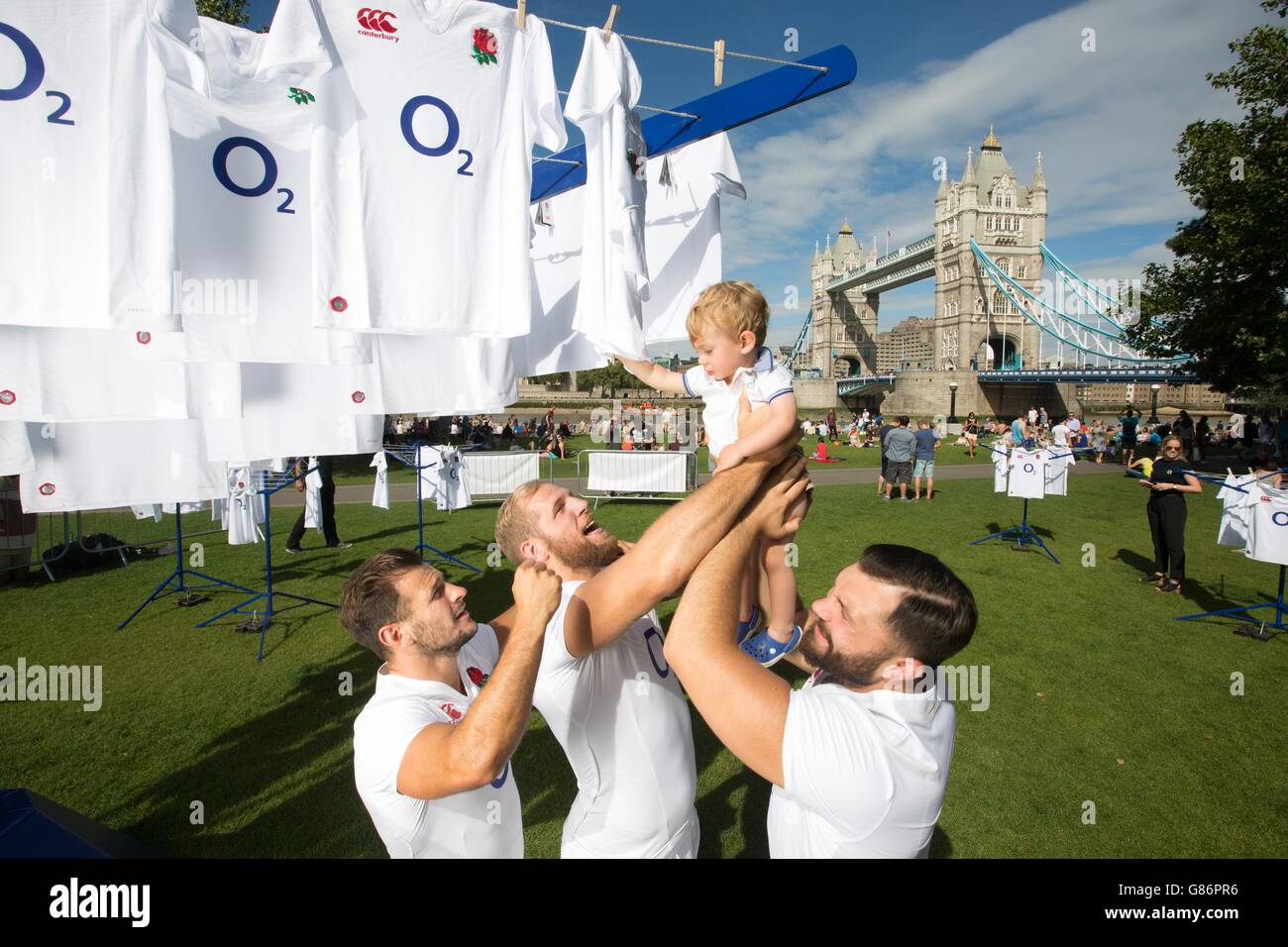 REDAKTIONELLE VERWENDUNG NUR England Rugby-Nationalspieler (von links) Danny Care, James Haskell und Alex Corbisiero heben den einjährigen Monty Cawley bei der Vorstellung des #WearTheRose Trikot-Giveaway von O2 im Londoner Potters Fields Park. Stockfoto