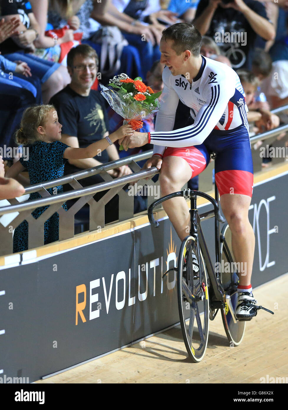 Der britische Lewis Oliver schenkt einem jungen Mädchen in der Menge seinen Blumenstrauß, nachdem er am zweiten Tag der Revolution Series in der Derby Arena das Sprint-Finale der Männer gewonnen hat. Stockfoto