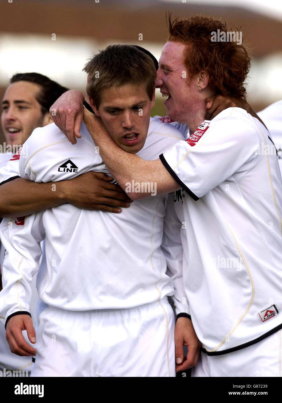 GARETH EDDs (L) VON MK Don wird von Teamkollegen nach dem Tor gegen Tranmere Rovers gratuliert. Stockfoto