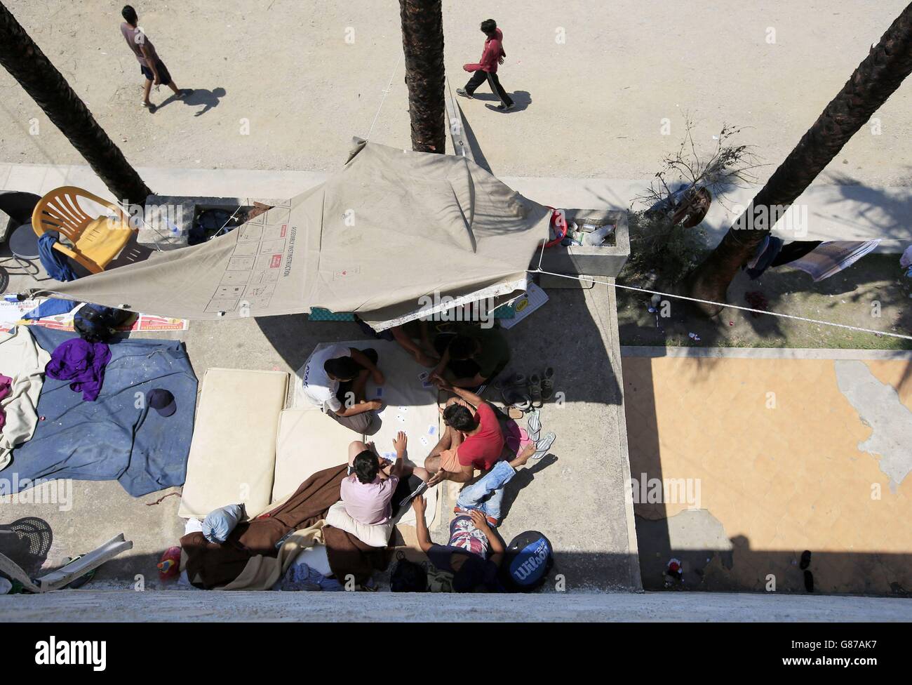 Migranten, die Schutz suchen, spielen Karten im verderbten Captain Elias Hotel in Kos-Stadt, Kos, Griechenland. Stockfoto