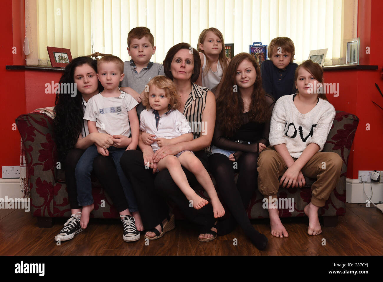 Tracy Foster mit ihren Kindern (von links nach rechts) Grace, 16, Billy, 3, Lenny, 12, Fredrick, 2, April 7, Faith, 15, Stanley, 6 und Eily, 10 in ihrem Haus in Great Barr, Birmingham. Stockfoto