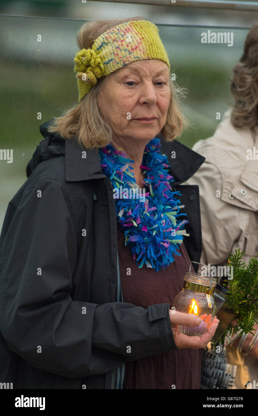 Eine Frau hält während einer Mahnwache bei Kerzenschein auf der Adur Ferry Bridge in Shoreham, Sussex, eine Kerze in der Hand, um an die Opfer des Absturzes der Shoreham Airshow zu erinnern. Stockfoto