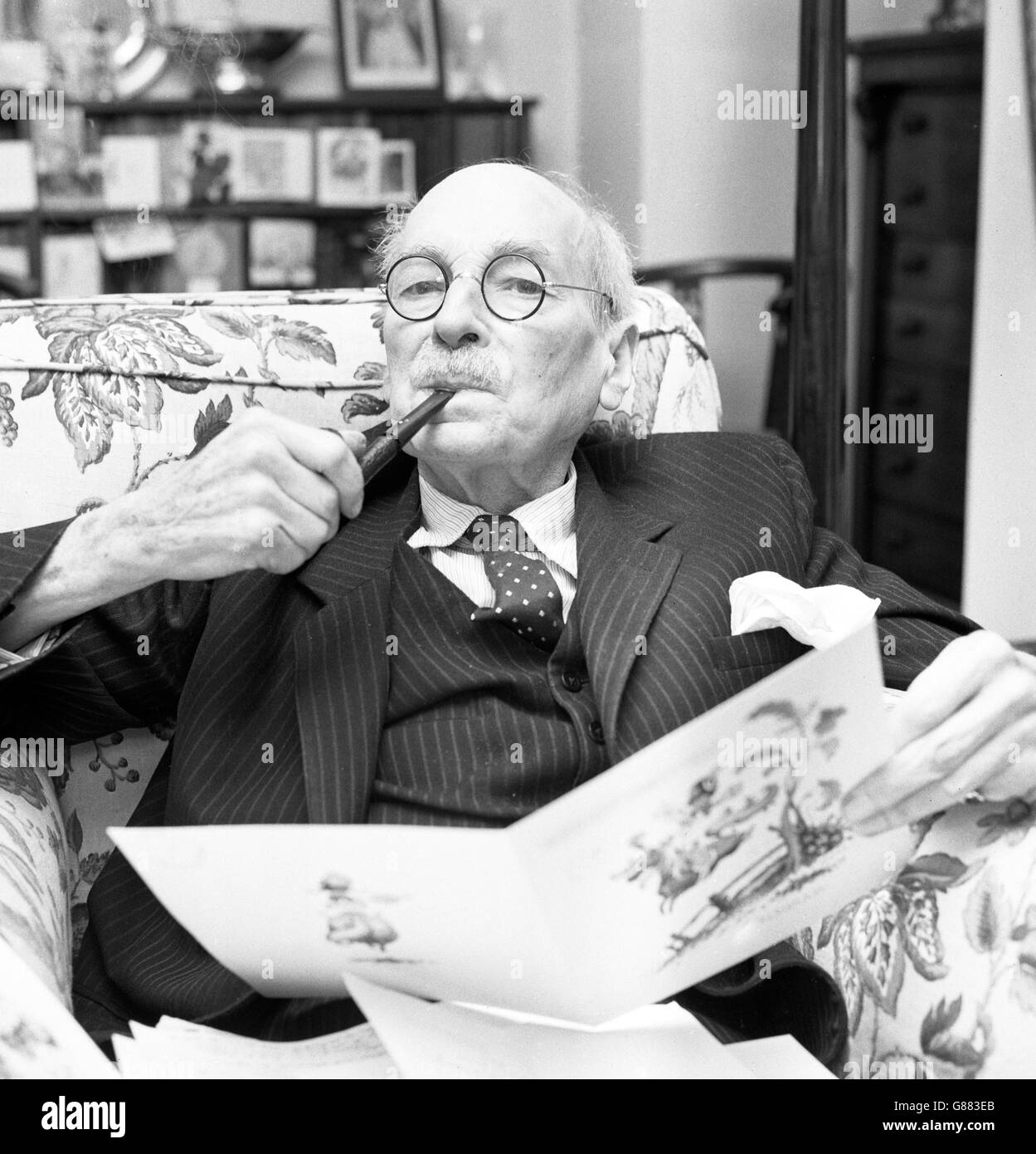 Earl Attlee raucht eine Pfeife, während er seine Glückstelegramme zu seinem 83. Geburtstag in seiner Wohnung im Londoner Tempel liest. Stockfoto