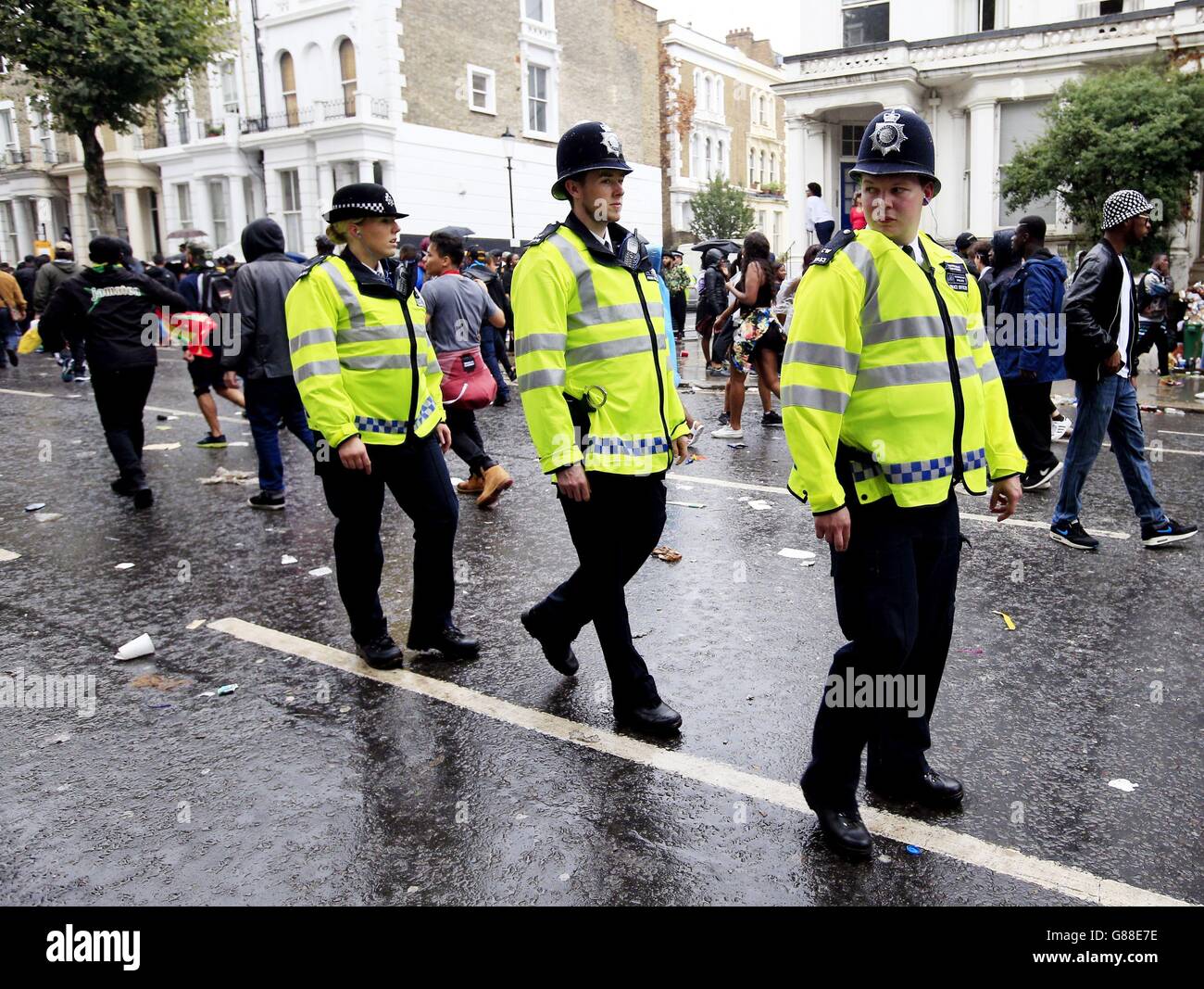 Während des Notting Hill Carnival, London, läuft die Polizei auf Ladbroke Grove unter Nachtschwärmern. Stockfoto