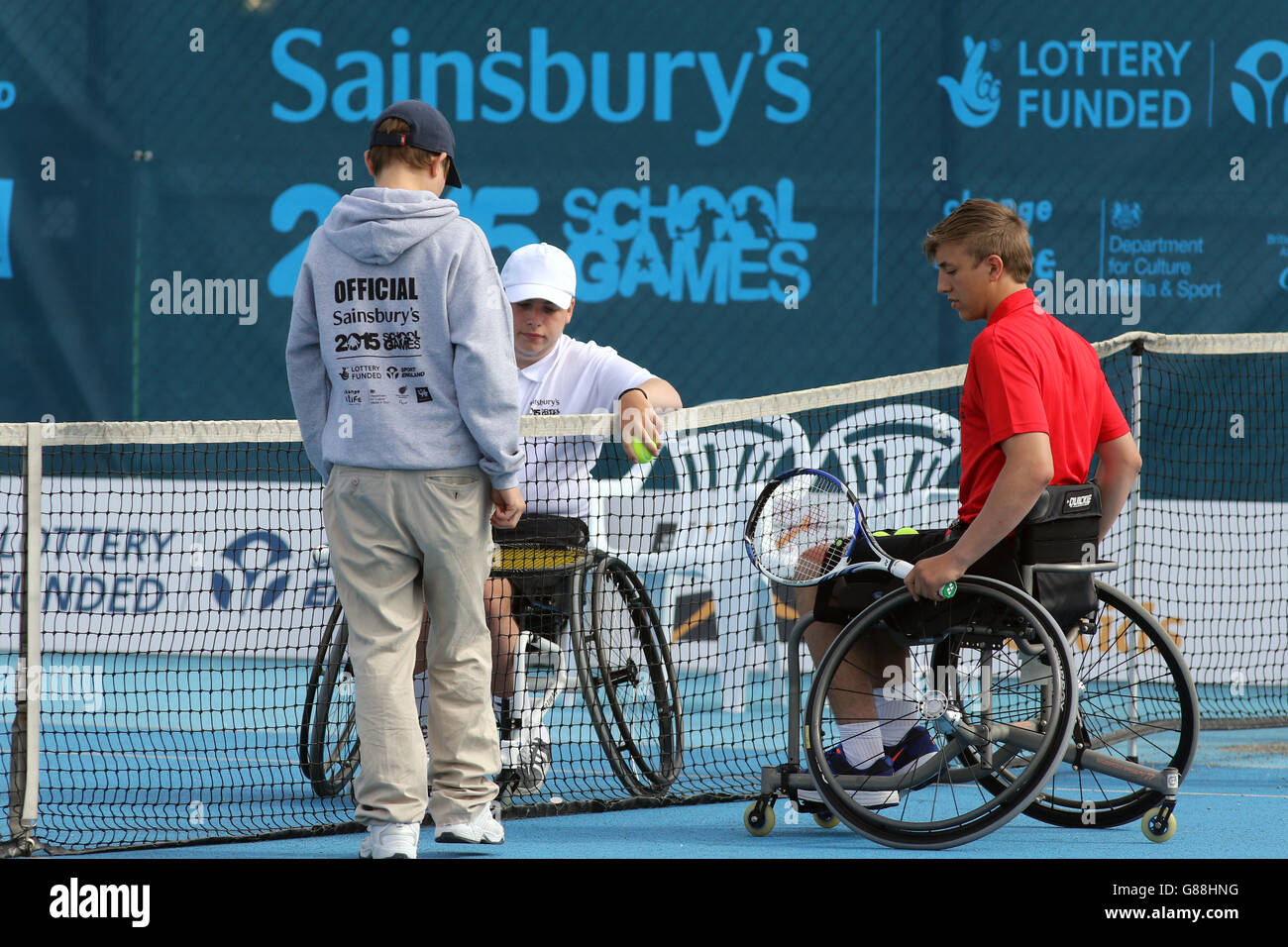 Der englische George Jeremiah (Mitte) spricht und der walisische Ben Johnson-Rolfe spricht mit einem Spielbeamten während des Rollstuhltennisports bei den Sainsbury's School Games 2015 im Regional Tennis Center, Manchester. Stockfoto