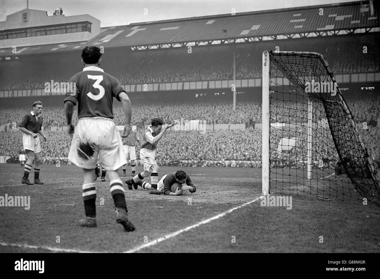 Chelsea-Torhüter Harry Medhurst (r) rettet unter dem Druck von Arsenals Jimmy Logie (zweite r), während die Teamkollegen Billy Hughes (3) und Frank Mitchell (l) aufschauen Stockfoto