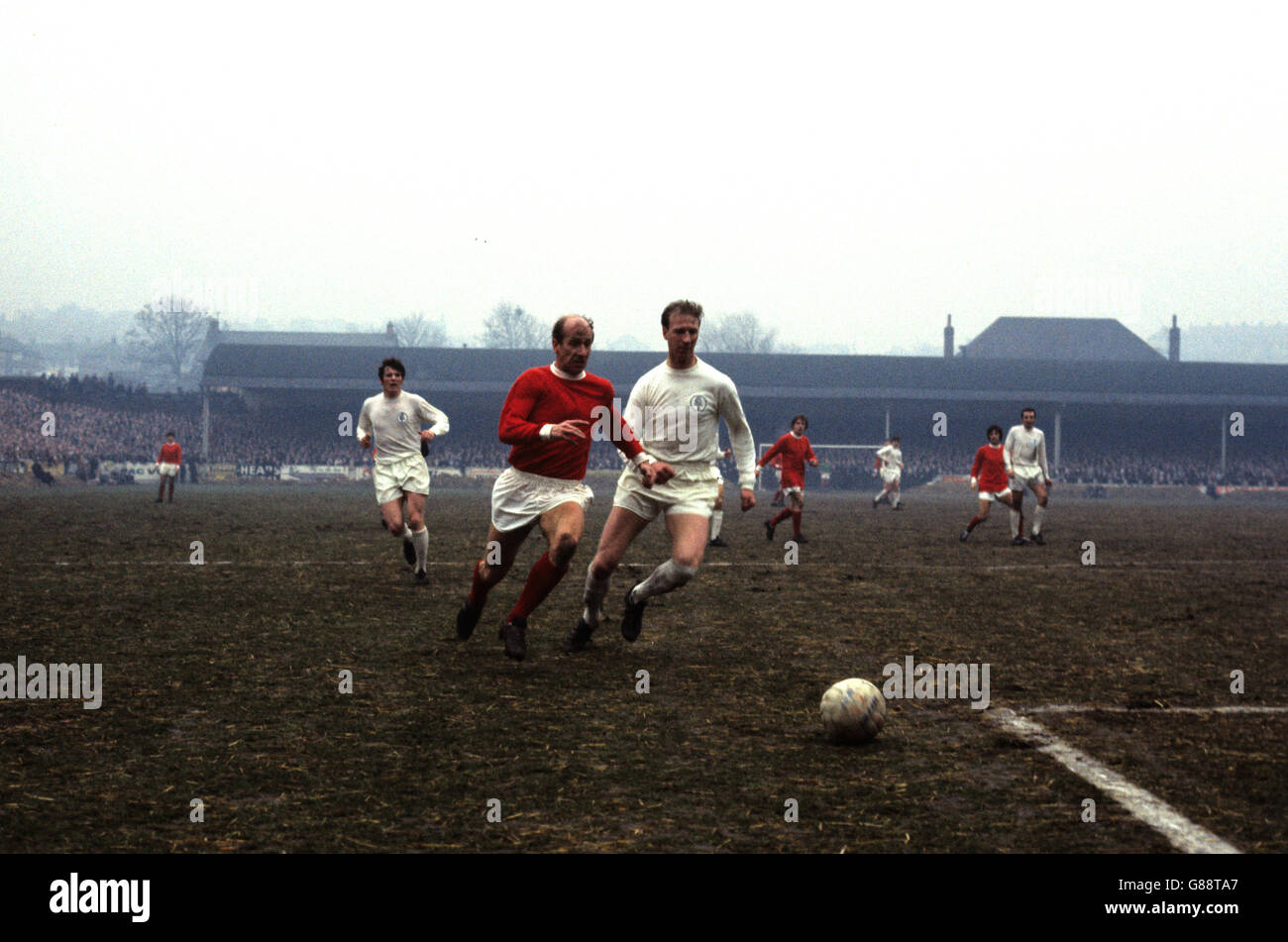 Bobby Charlton von Manchester United (rot) und sein Bruder Jackie von Leeds United Rennen um den Ball. Stockfoto
