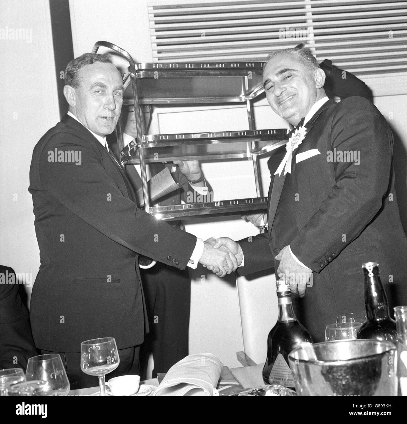 Arsenal-Manager Billy Wright (links) erhält einen Tee-Trolley von Lewis Hill, Präsident der Londoner Gegend der Furniture Trades Benevolent Association im London Hilton Hotel. Er wurde für seine Verdienste um den Fußball in einer Zeremonie geehrt, die während eines Boxabends vom Anglo-American Sporting Club organisiert wurde. Stockfoto