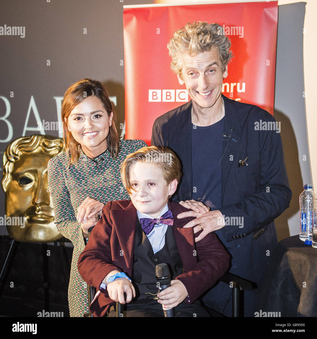 Jenna Coleman und Peter Capaldi posieren für ein Foto mit George Buckland, 11, aus Nottingham, auch bekannt als 'Mini Matt Smith', nachdem er mit der Besetzung auf die Bühne eingeladen wurde und um seine Aufnahme mit den Schauspielern von Cineworld in Cardiff bat, Wo Episoden für die neue DR Who-Serie gescreent werden. Stockfoto