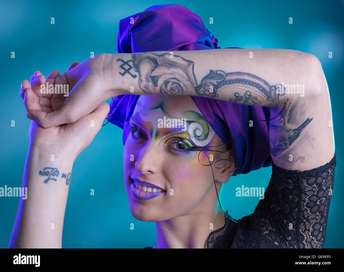 Weibliches Model Portrait mit tribal kreative Make-up wirbeln und lila Turban, Tattoos, Körperkunst, Tinte, schwarzen Spitzenkleid Stockfoto