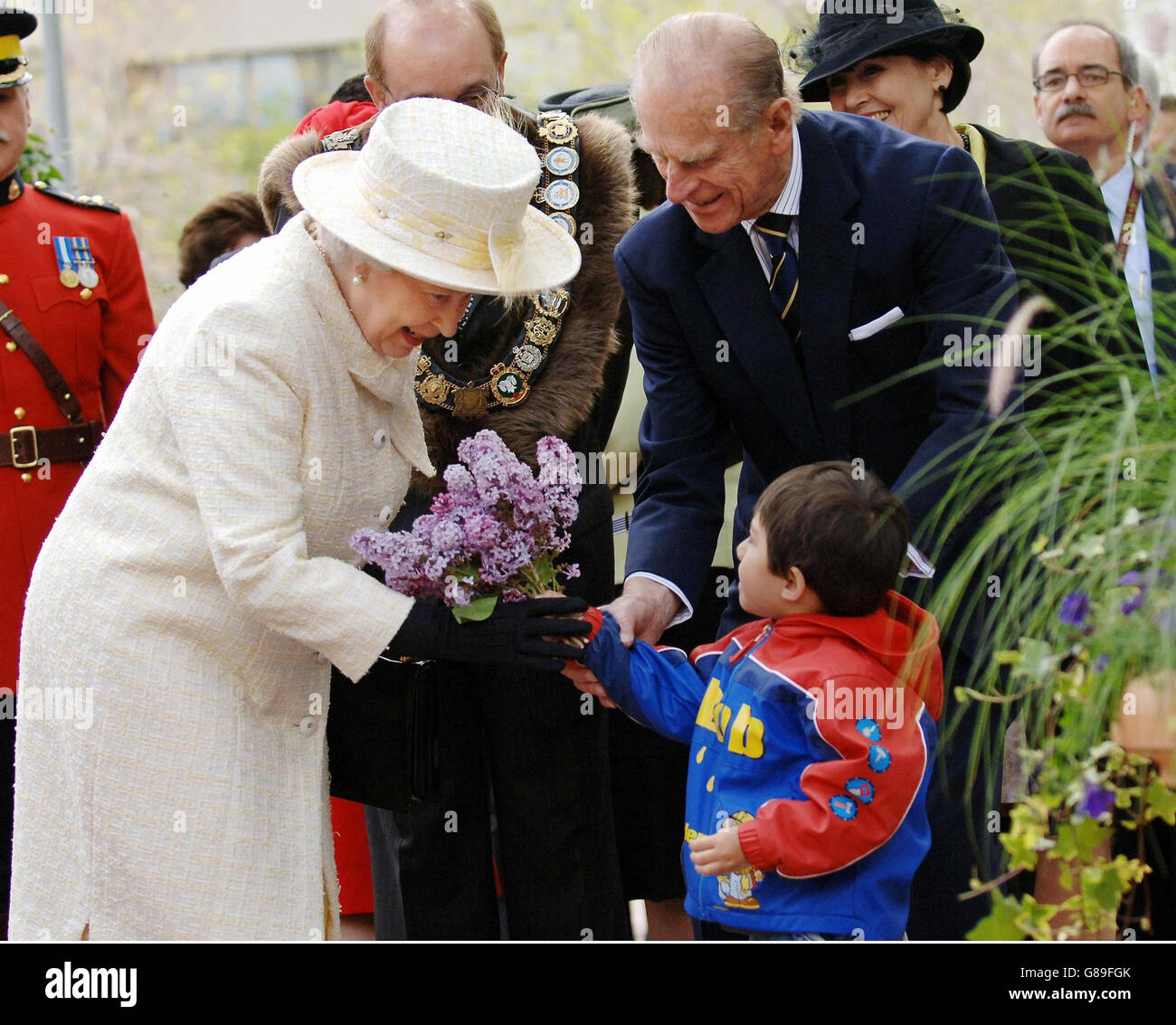 Königin Elizabeth II. Und der Herzog von Edinburgh nehmen am letzten Tag des königlichen Besuches in Kanada Blumen eines kleinen Kindes auf dem Sir Winston Churchill Square, Edmonton, entgegen. Stockfoto