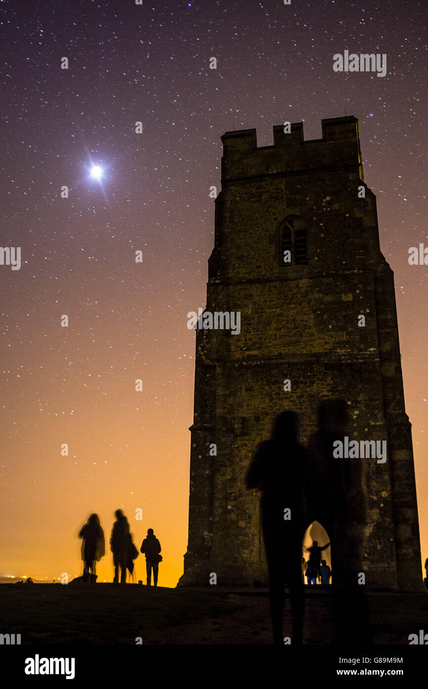 Die Menschen beobachten den Supermond vom Gipfel des Glastonbury Tor aus, kurz bevor der Erdschatten den hellen Mond vollständig bedeckt und eine totale Finsternis erzeugt. Stockfoto