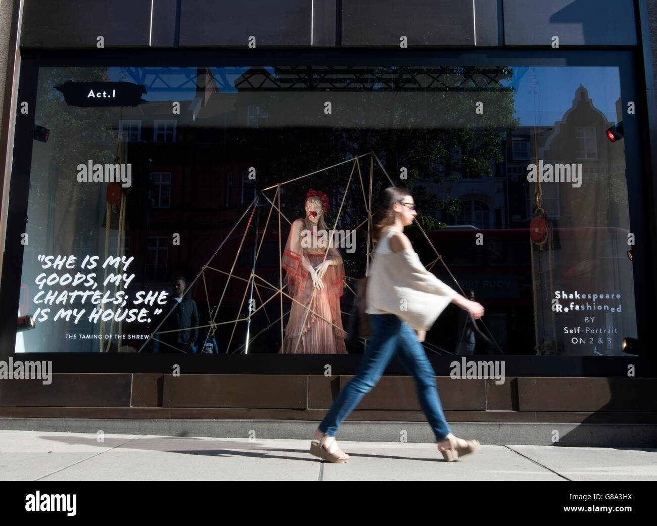 Eine Frau geht durch das Selbstporträt-Fenster bei Selfridges in London, wie der Shop startet Sommer Shakespeare Feierlichkeiten zum 400. Todestag des Barden mit neuen Schaufenster mit visuelle Interpretationen einiger seiner beliebtesten Stücke von Modedesignern. Stockfoto