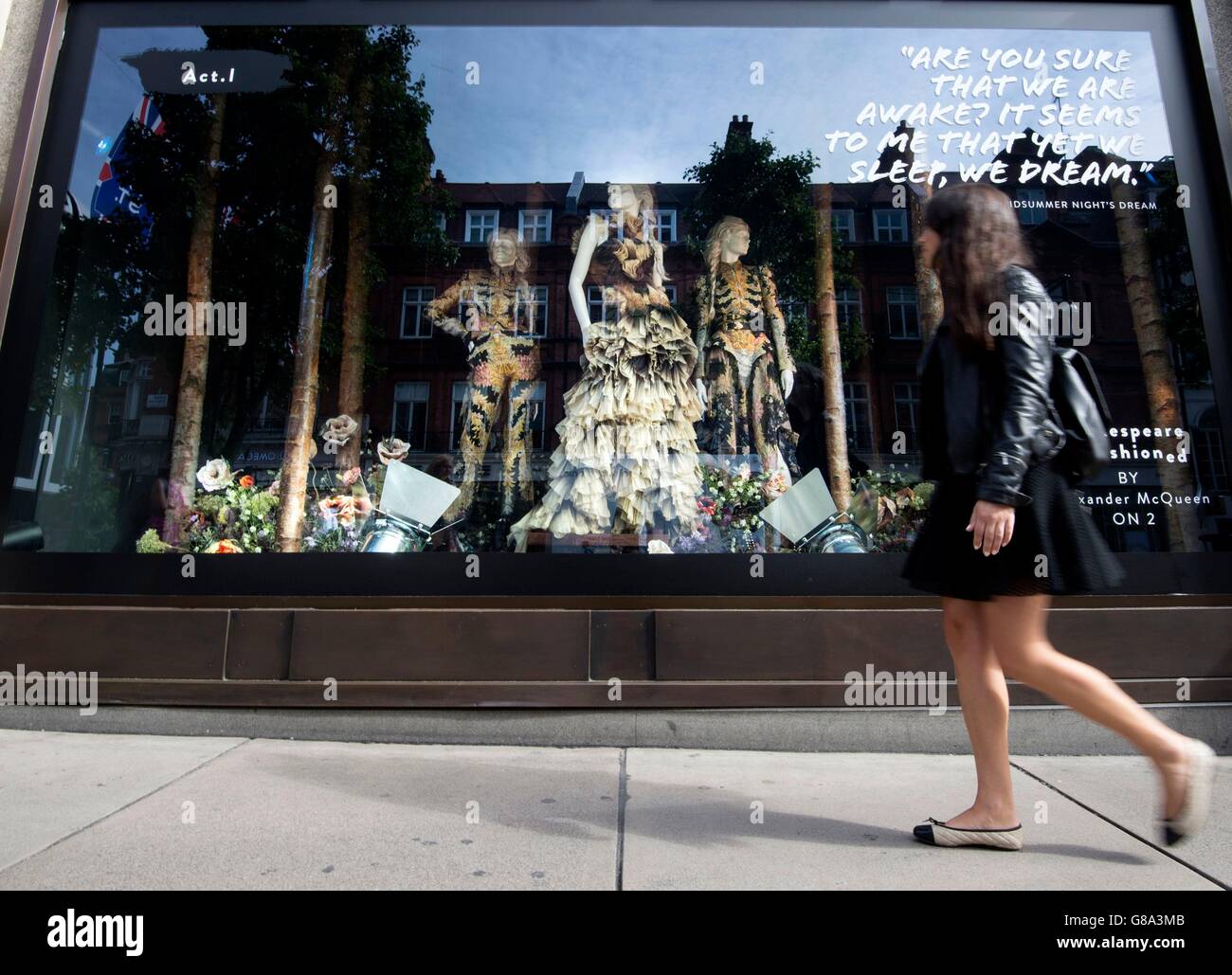 Eine Frau geht durch die Alexander McQueen-Fenster bei Selfridges in London, wie der Shop startet Sommer Shakespeare Feierlichkeiten zum 400. Todestag des Barden mit neuen Schaufenster mit visuelle Interpretationen einiger seiner beliebtesten Stücke von Modedesignern. Stockfoto