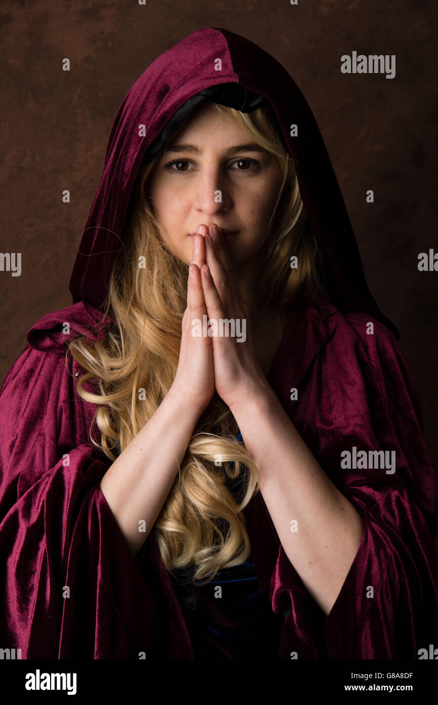 Fantasy-Makeover-Fotografie: eine junge Frau-Modell trägt eine blonde Perücke und einen lila Umhang posiert als Priesterin in einem "game of Thrones" oder "Göttin der Erde" inspiriert Sitzung Stockfoto