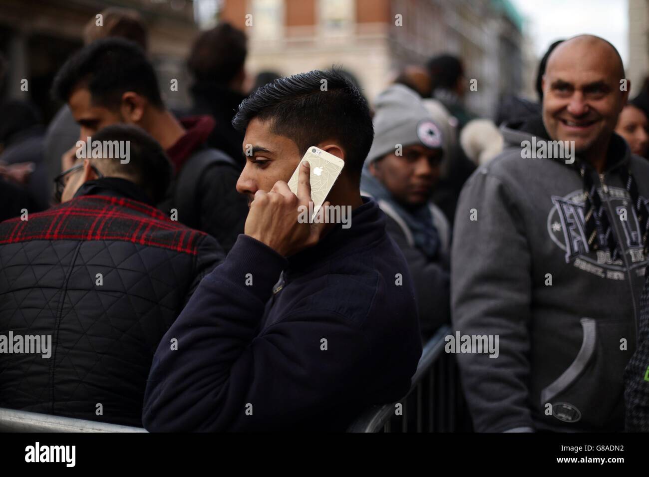 Ein Mann spricht auf seinem iPhone, wie er Schlange für die neuen Apple iPhone 6s im Apple Store in Covent Garden, London. Stockfoto