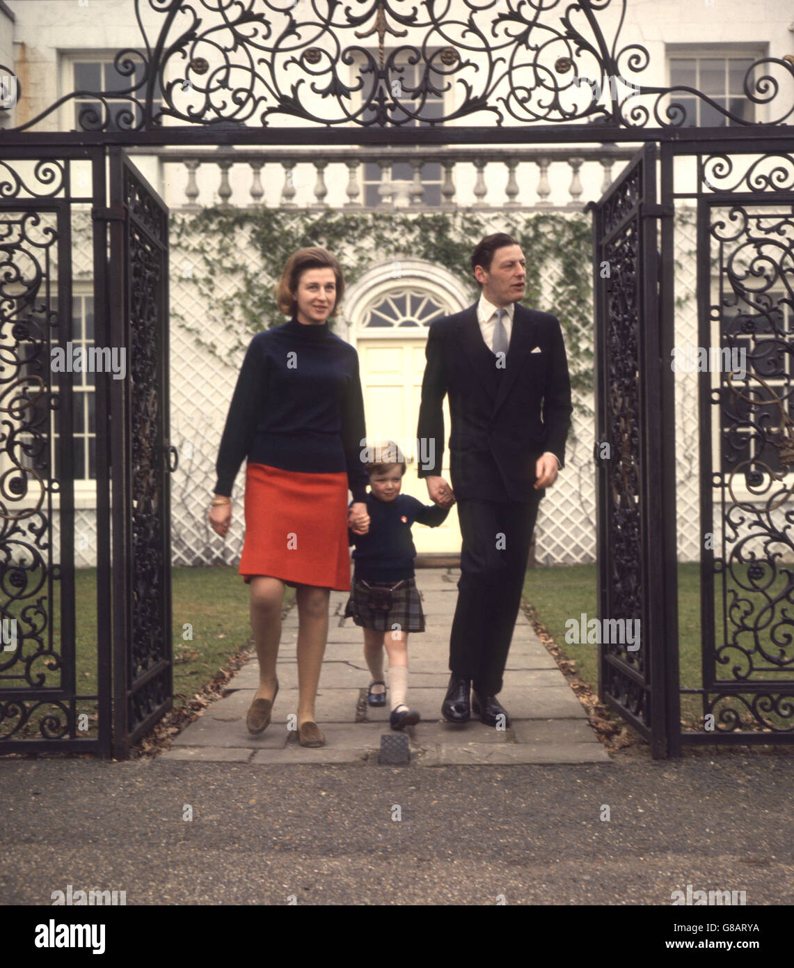 LEAP-year Baby, kilted James Ogilvy, Walking Hand in Hand mit seinen Eltern Prinzessin Alexandra und Angus Ogilvy in ihrem Haus, Reetgedeckten House Lodge, Richmond Park. Stockfoto