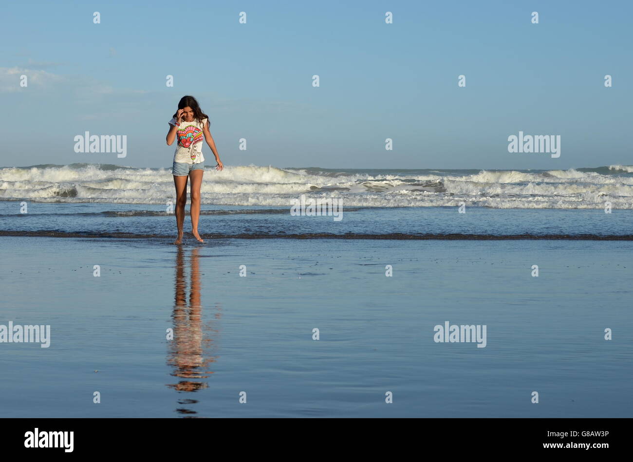 Mädchen Strand entlang spazieren Stockfoto