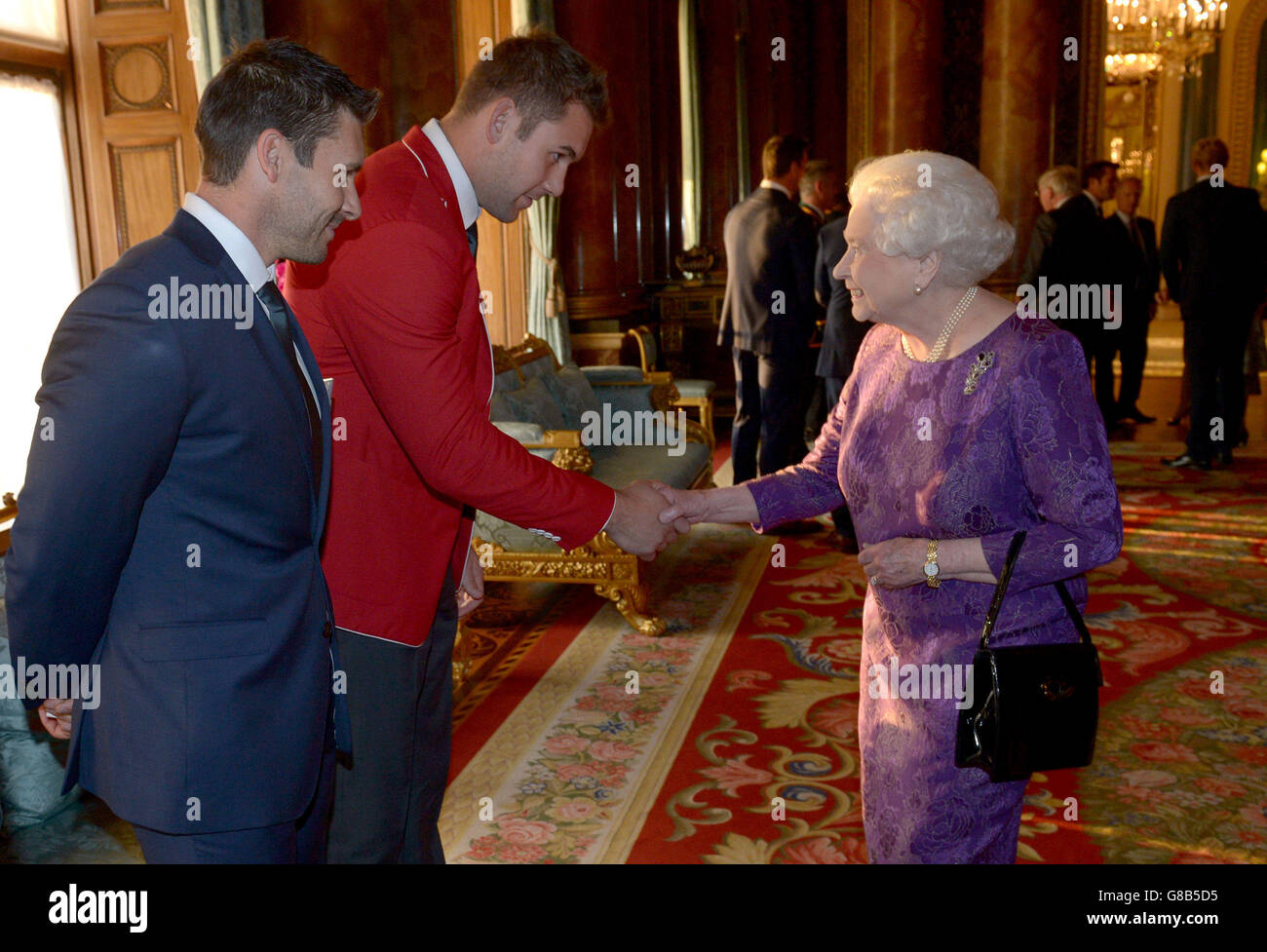 Queen Elizabth II trifft auf den kanadischen James Pritchard (links) und Jebb Sinclair (Mitte) bei einem Rugby-Weltmeisterschaft-Empfang im Buckingham Palace, London. Stockfoto