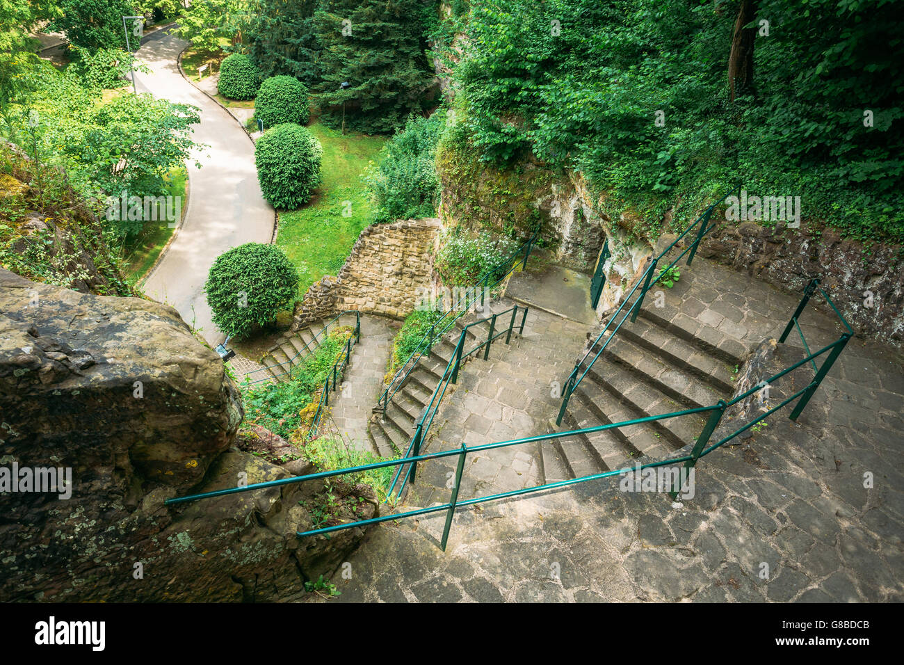 Pathway Gehweg Lane Pflasterweg mit grünen Bäumen und Büschen im Park. Schöne Gasse im Sommerpark Stockfoto