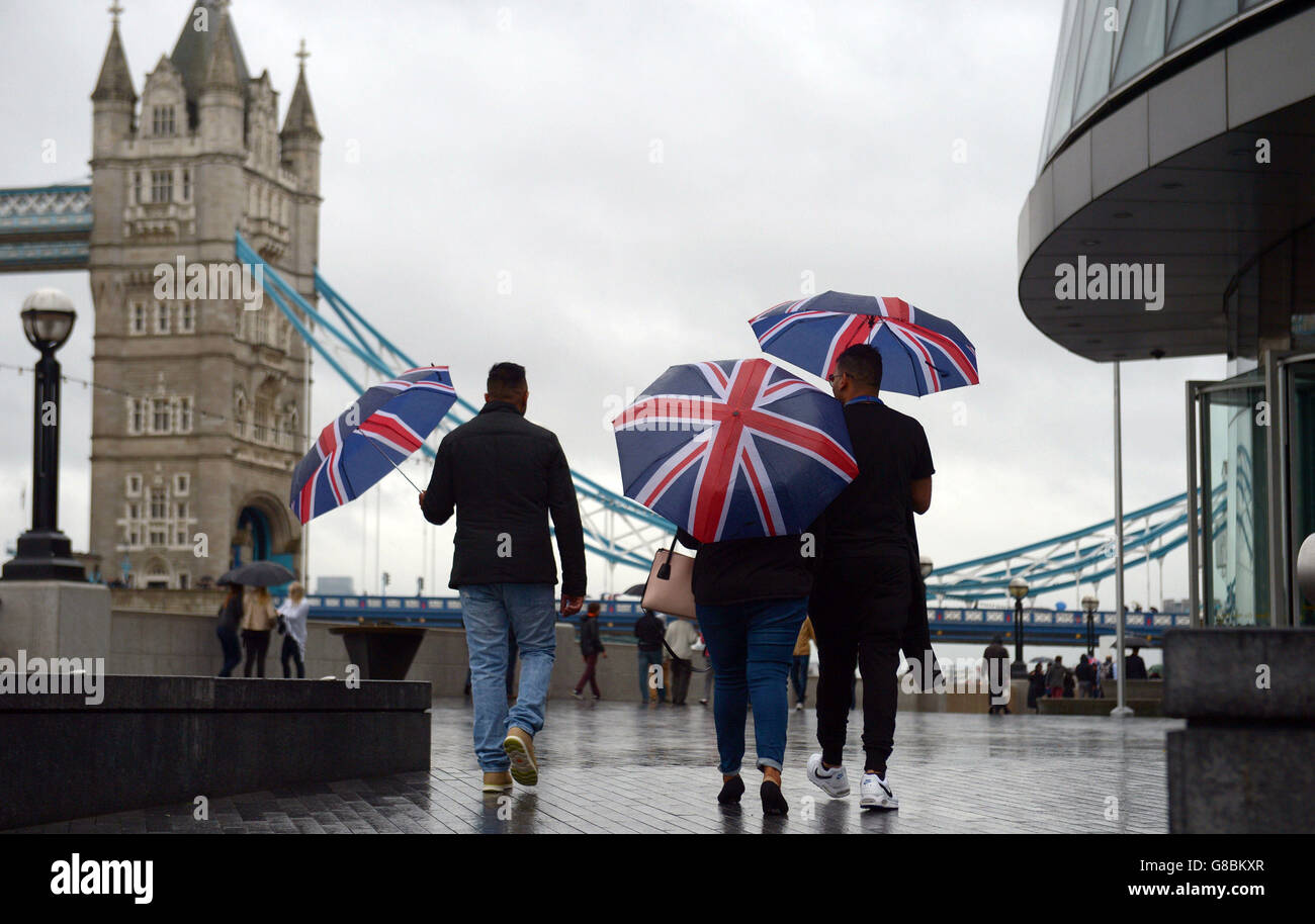 Vor dem City Hall, London, schützen sich die Menschen unter Regenschirmen vor dem Regen, da Großbritannien am Wochenende von den Überresten des Hurrikans Joaquin getroffen werden könnte, wenn das nasse und windige Wetter zurückkehrt und die Temperaturen sinken. Stockfoto