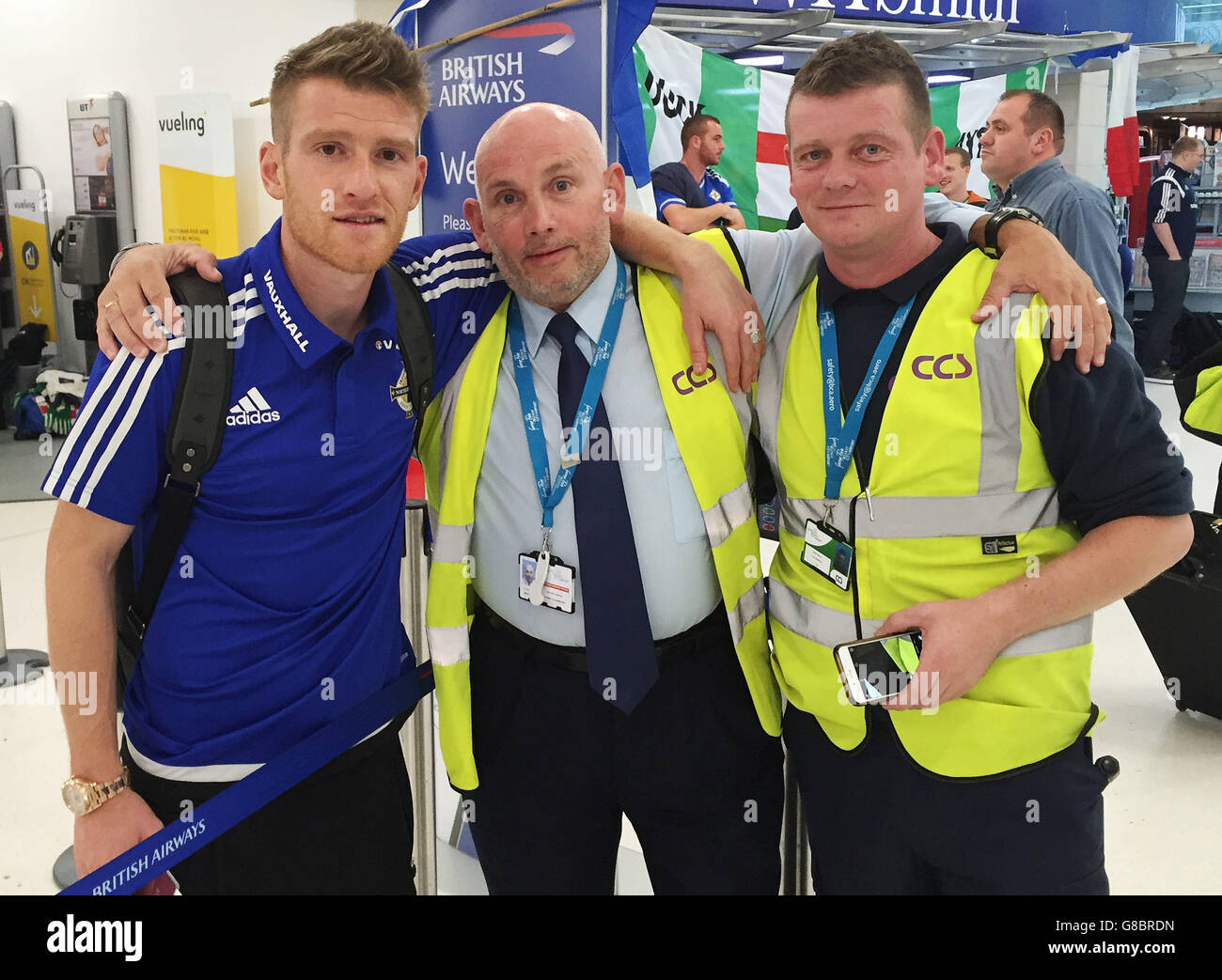 Der nordirische Fußballkapitän Steven Davis mit Sicherheitspersonal am Flughafen von Belfast City, Stunden nachdem das Team in das Finale der Europameisterschaft gestürmt war. Stockfoto