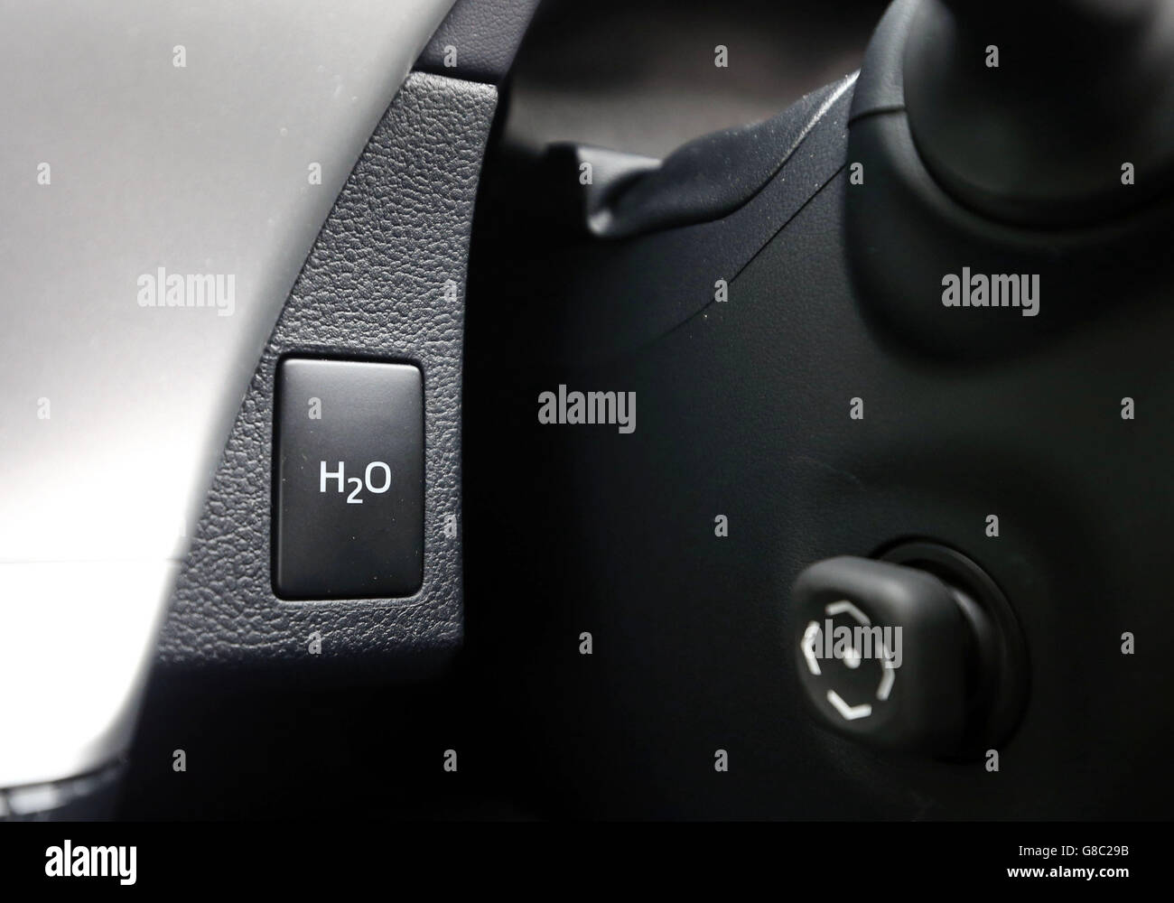 Der Knopf, um Wasser aus dem Auspuffrohr des ersten Massenproduktion gewidmet Wasserstoff Brennstoffzelle Fahrzeug, der Toyota Mirai, wie es geht durch sie Schritt in Denham, Buckinghamshire zu verteilen. Stockfoto