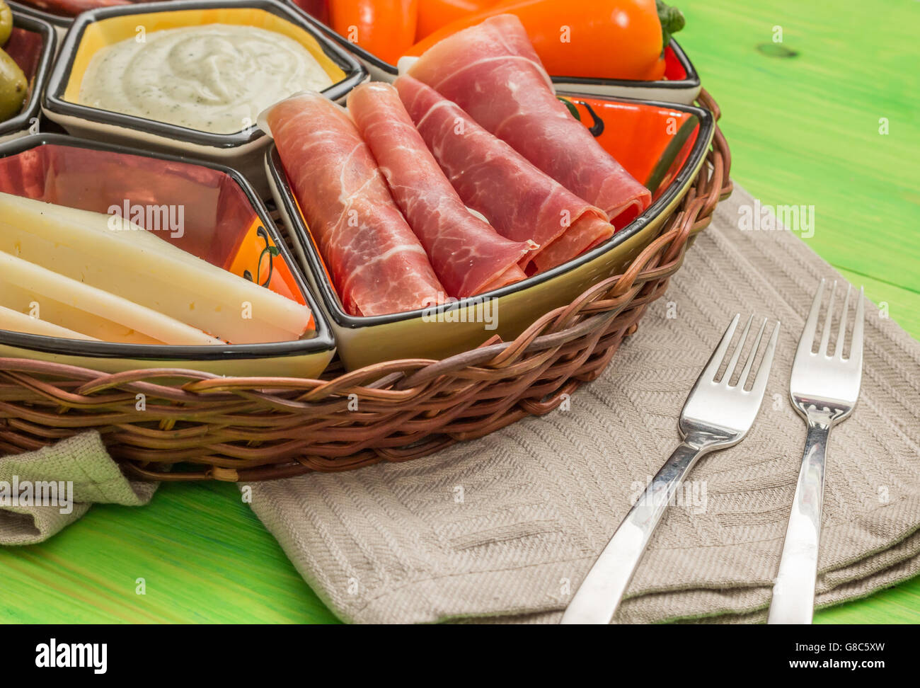 Korb mit spanischen Tapas auf einem rustikalen Holztisch grün Stockfoto