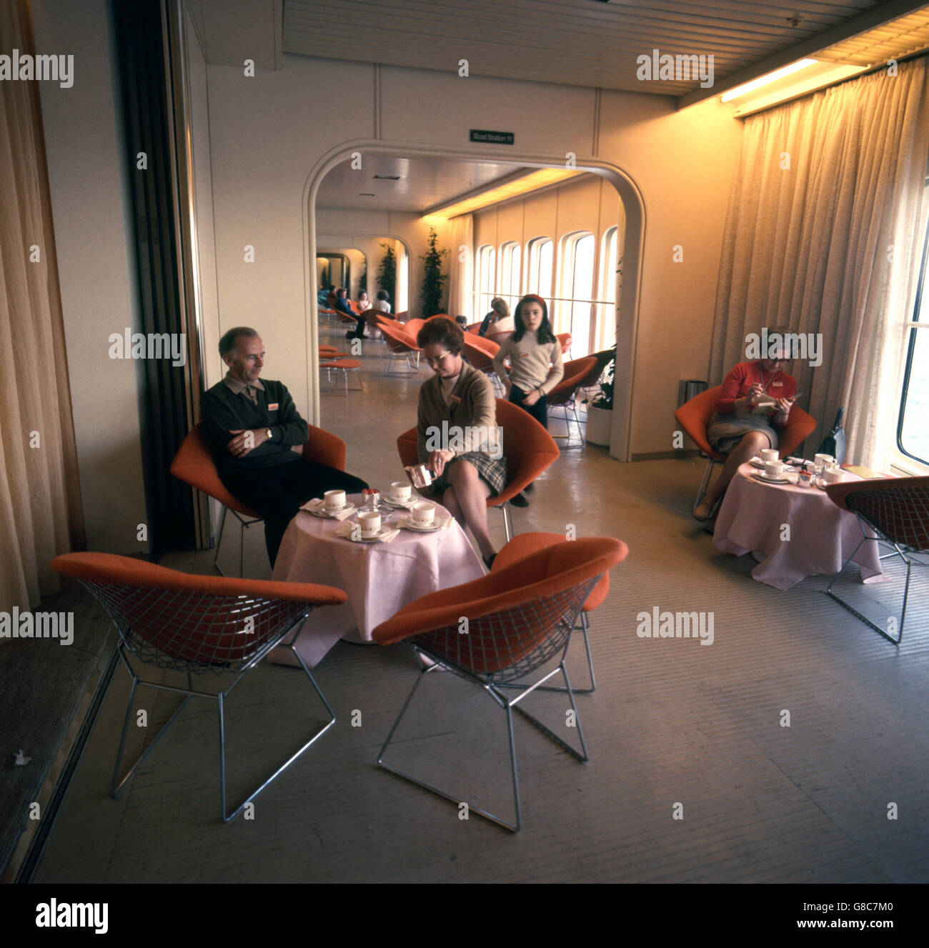 Passagiere, die in einer Lobby neben dem Queen's Room auf dem Vierteldeck des Cunard-Liners, Queen Elizabeth II, (QE2), Tee trinken. Stockfoto Passagiere, die in einer Lobby neben dem Queen's Room auf dem Vierteldeck des Cunard-Liners, Queen Elizabeth II, (QE2), Tee trinken. Stockfoto