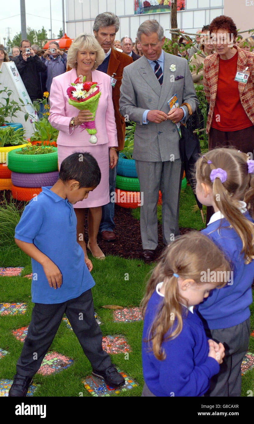 Der britische Prinz von Wales und die Herzogin von Cornwall beobachten die Kinder der St. Andrews Benn C der E-Schule von Rugby in ihrem Garten. Stockfoto