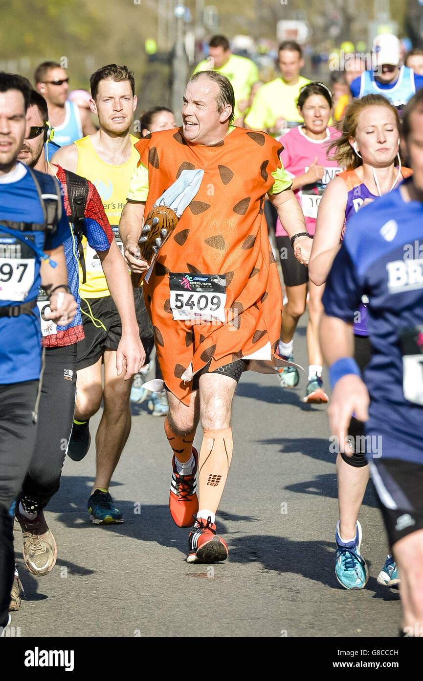 Ein Läufer, der als Höhlenmensch verkleidet ist, joggt entlang der Avon-Schlucht, während Tausende von Läufern beim ersten Bristol & Bath Marathon antreten. Stockfoto
