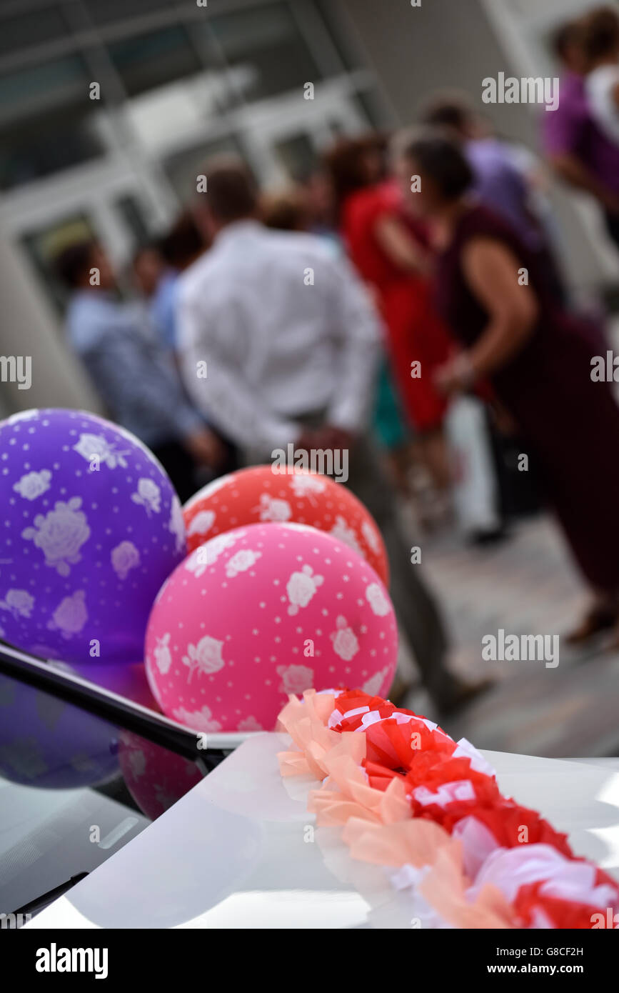 Mehrfarbige Luftballons auf Hochzeitsauto Stockfoto
