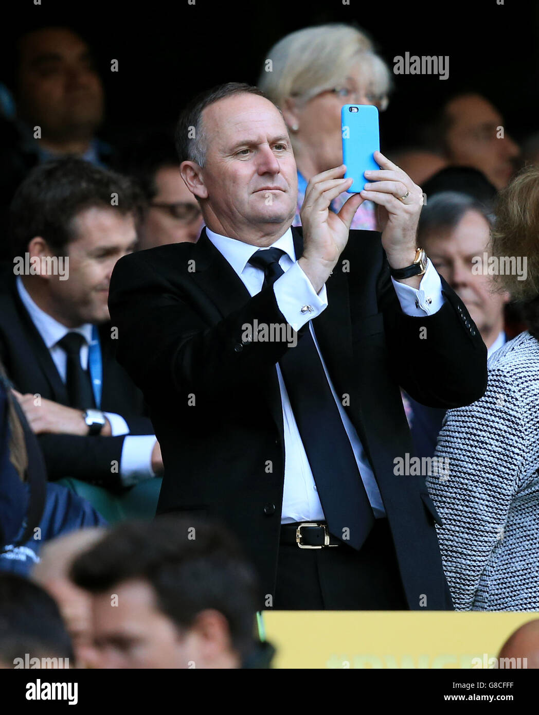 Der neuseeländische Premierminister John Key fotografiert während des Rugby-Weltcup-Finales in Twickenham, London, auf seinem Handy an den Ständen. Stockfoto