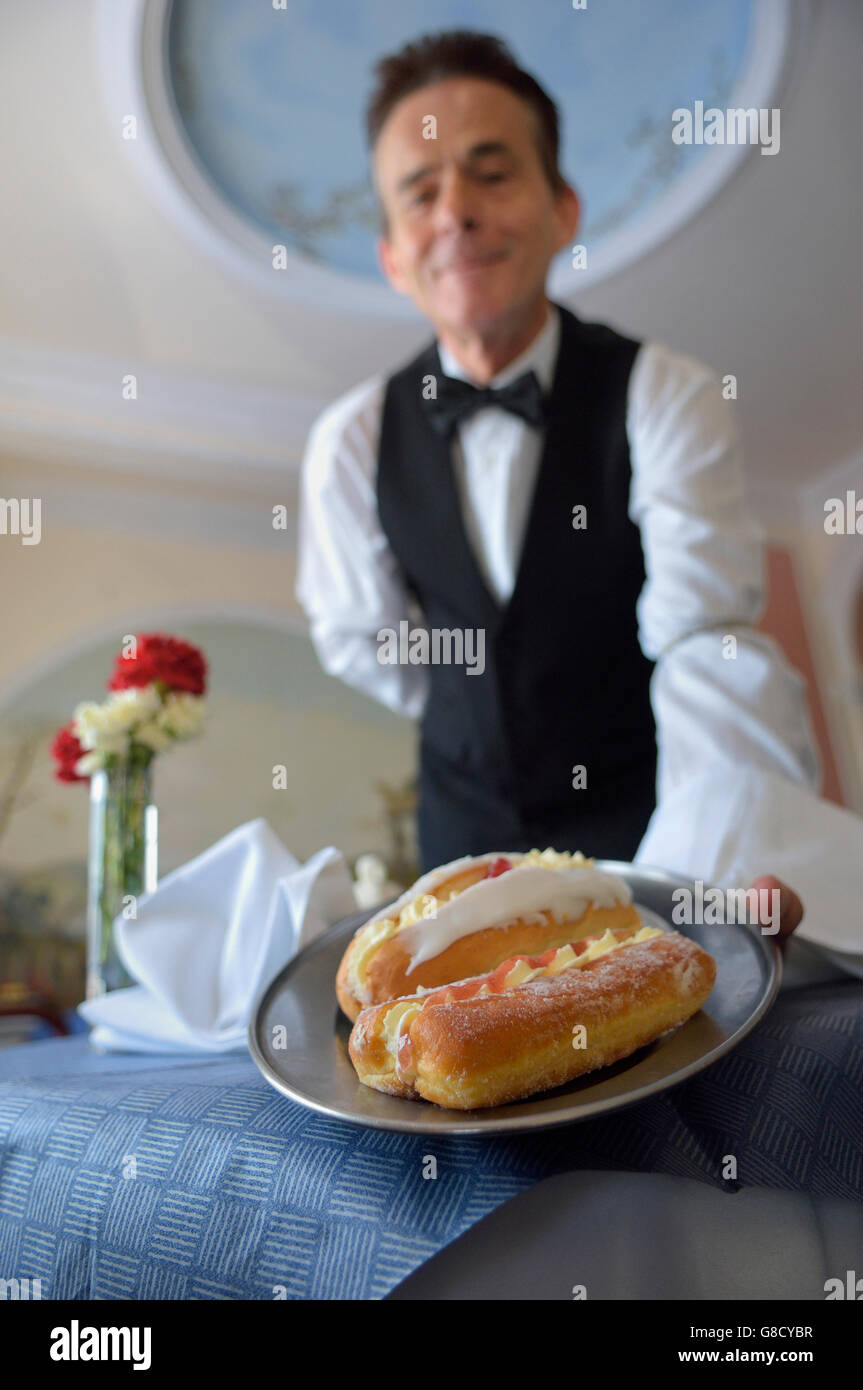 Ein Kellner serviert Sahnetorten Stockfoto