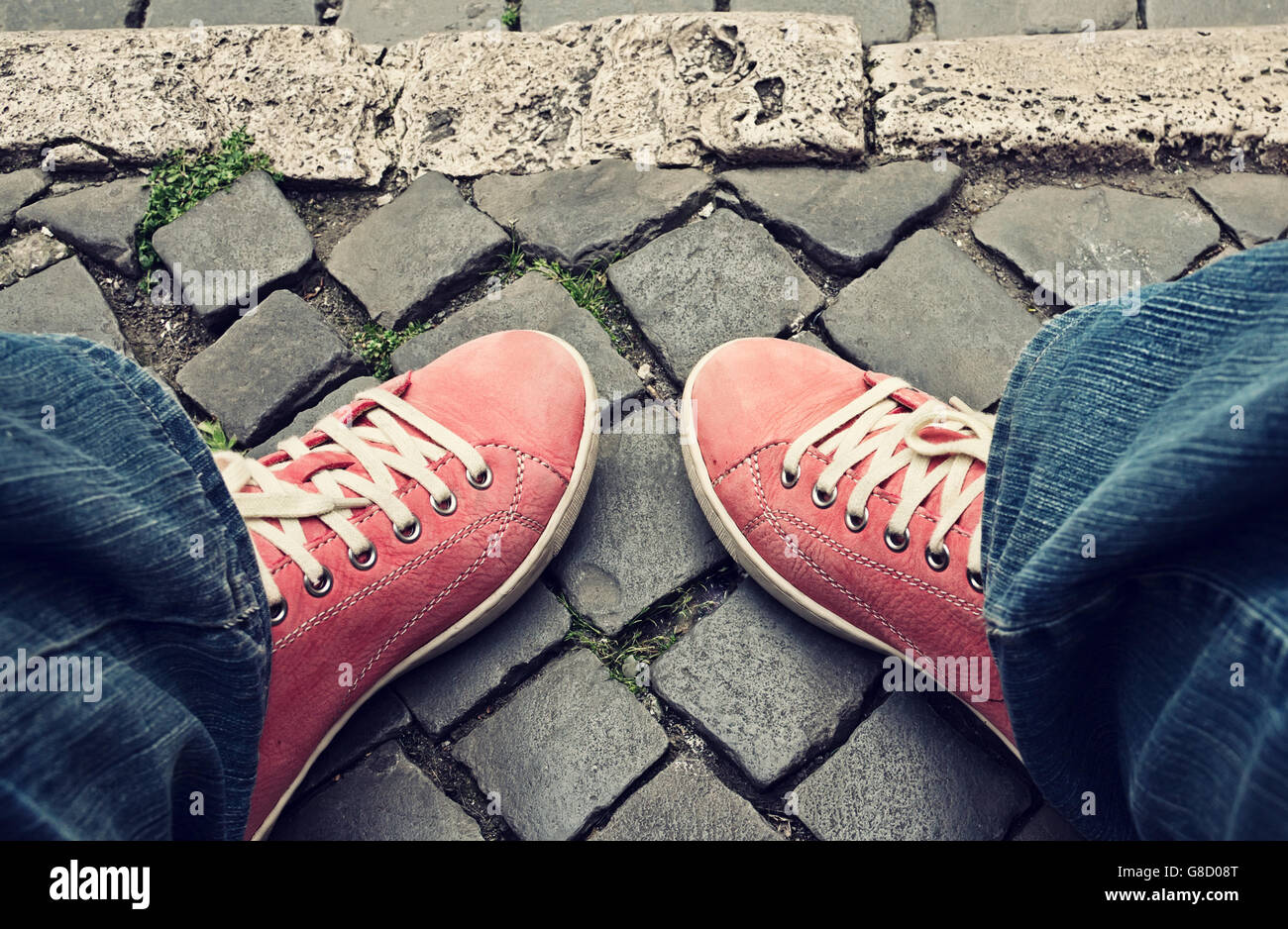 Füße in rote Turnschuhe und Jeans im Freien. Wahl der Art und Weise. Stockfoto